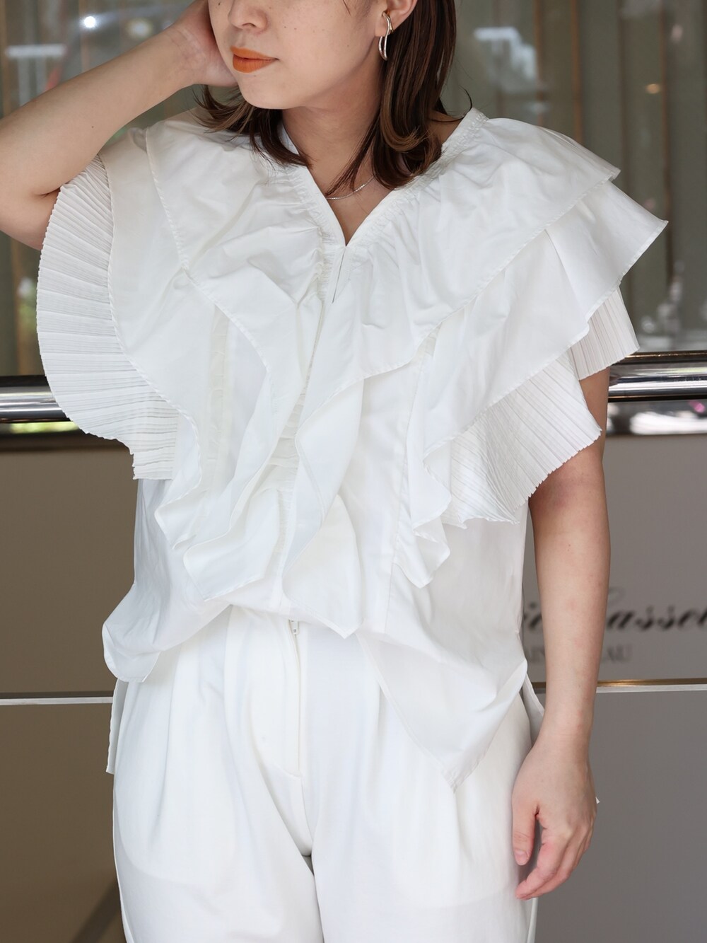 ホワイト系のスラックス、ベージュ系のパンプス、ホワイト系のシャツ/ブラウスを着用したレディースの春コーディネートの3枚目の写真