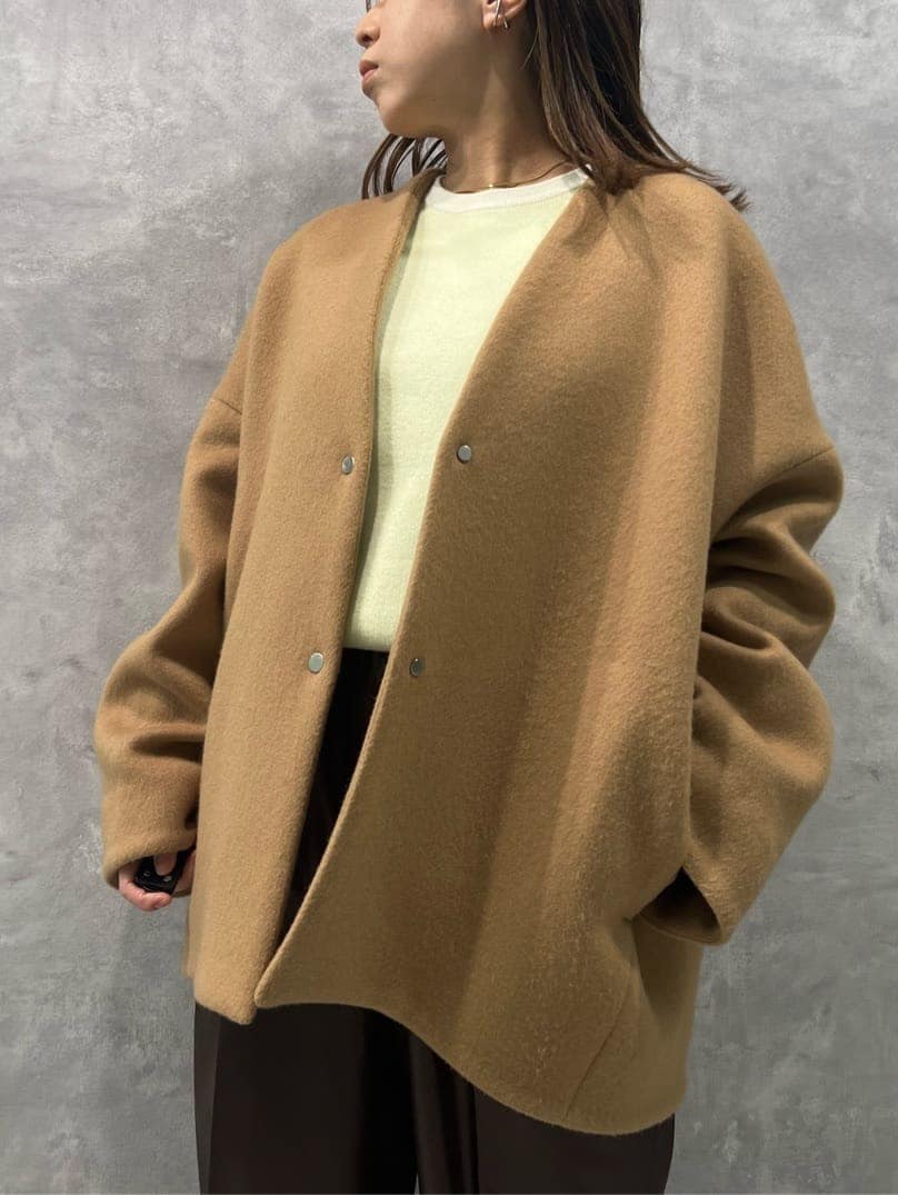 イエロー系のノーカラーコート、ブラウン系のその他パンツ、ホワイト系のニット/セーターを着用したレディースの秋コーディネートの5枚目の写真