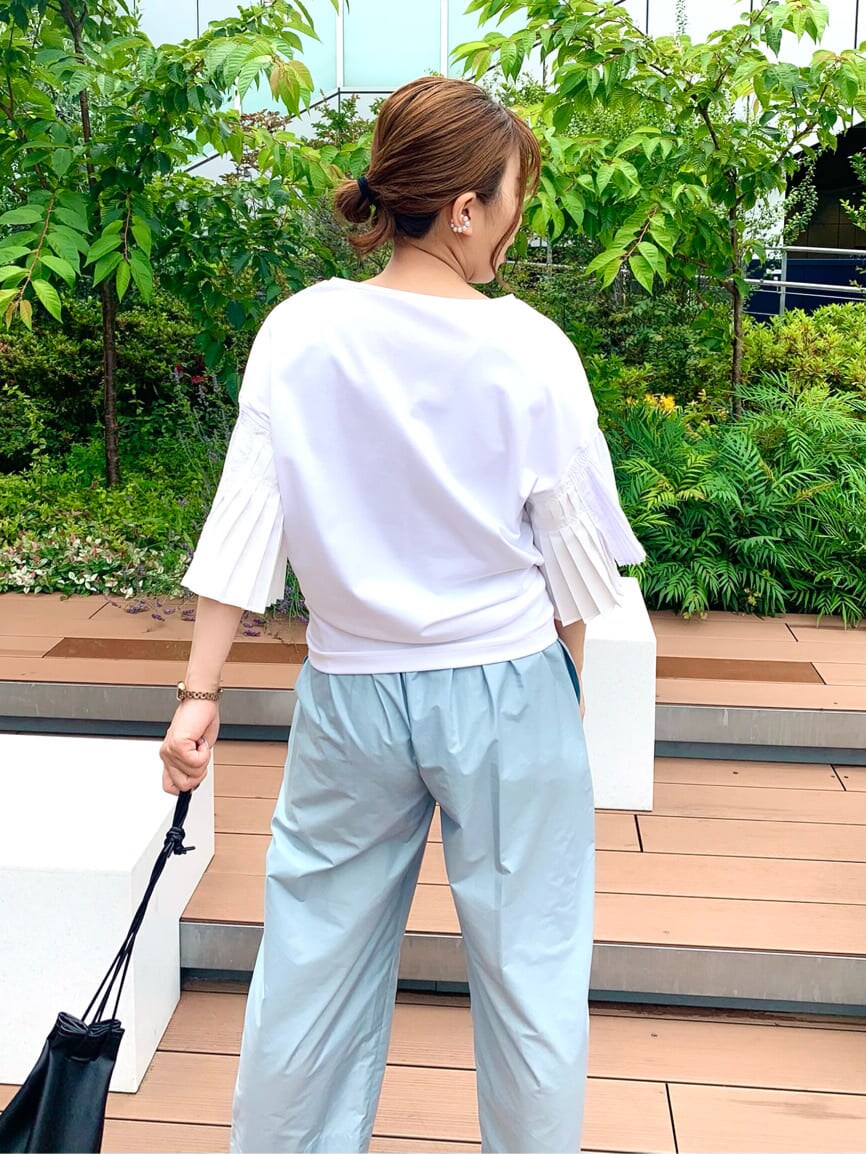 ブラック系のハンドバッグ、ホワイト系のTシャツ/カットソー、ブルー系のその他パンツを着用したレディースの夏コーディネートの3枚目の写真
