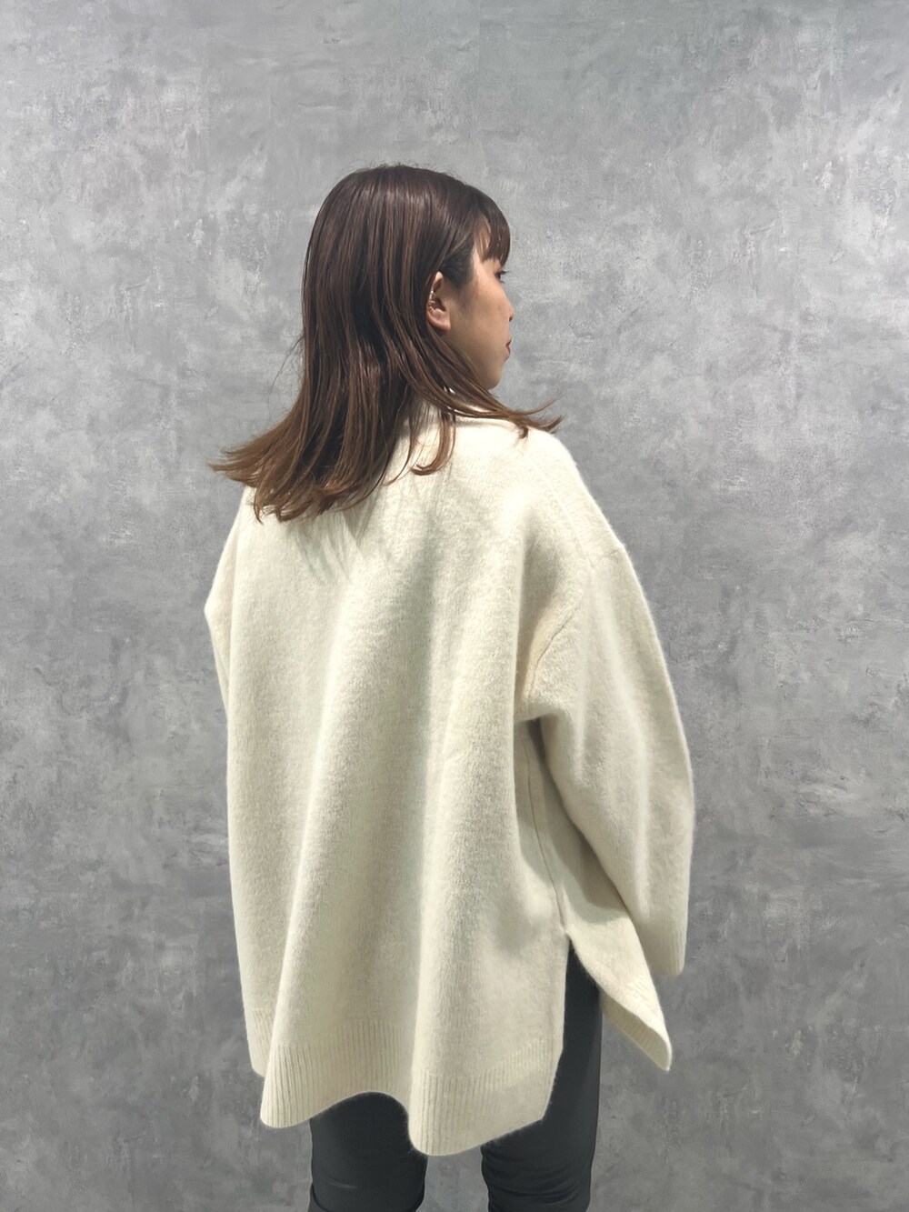 ホワイト系のニット/セーター、グレー系のその他パンツを着用したレディースの秋コーディネートの5枚目の写真