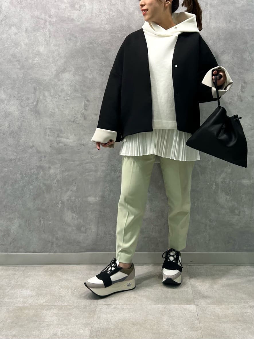 ブラック系のステンカラーコート、ピンク系のその他パンツ、ブルー系のスニーカーを着用したレディースの冬コーディネートの4枚目の写真