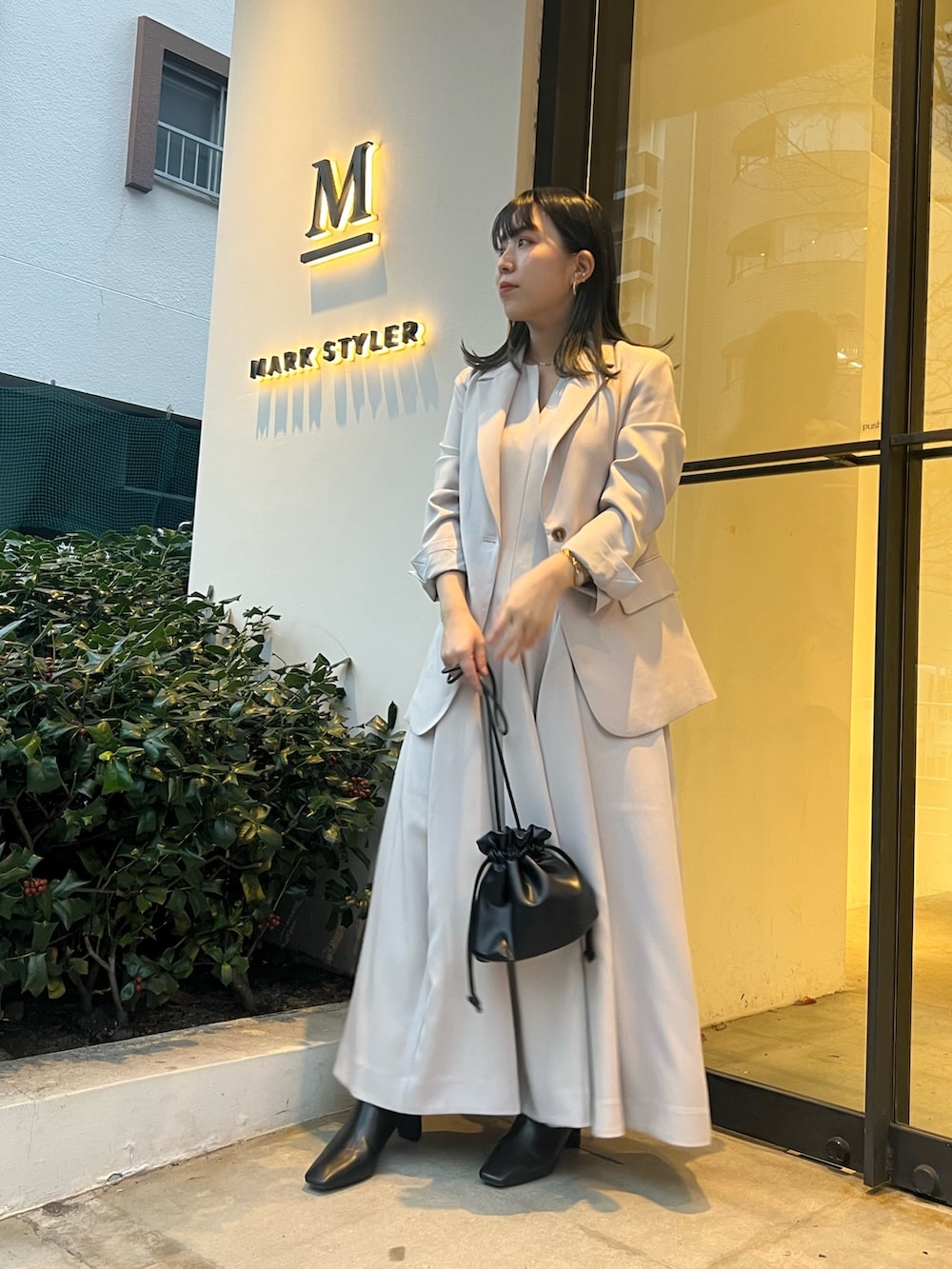 ベージュ系のテーラードジャケット、ベージュ系のワンピース、ブラック系のブーツを着用したレディースの冬コーディネートの2枚目の写真