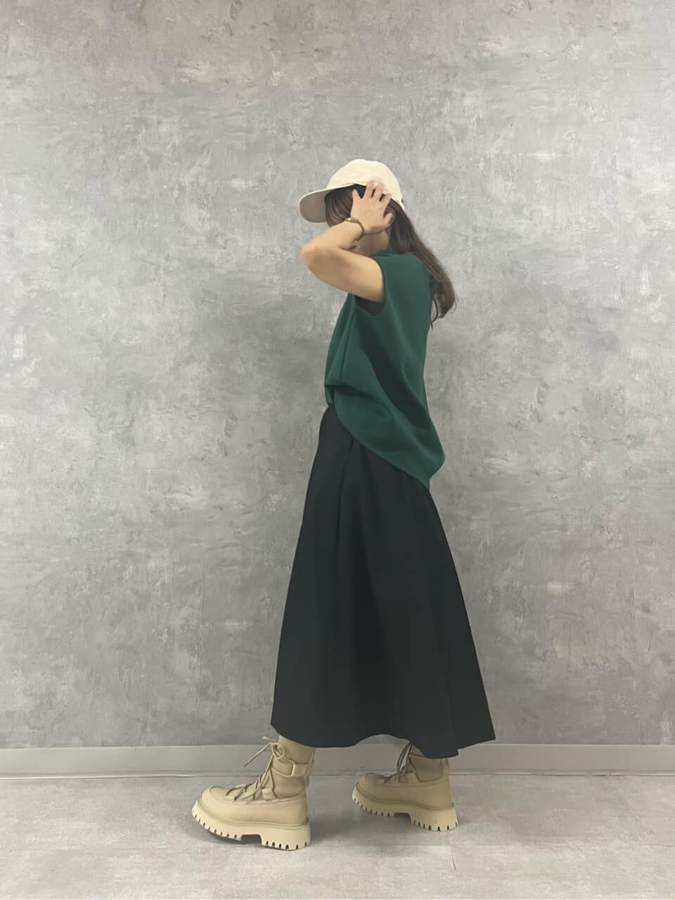 グリーン系のTシャツ/カットソー、ブラック系のスカート、ホワイト系のキャップを着用したレディースの夏コーディネートの4枚目の写真