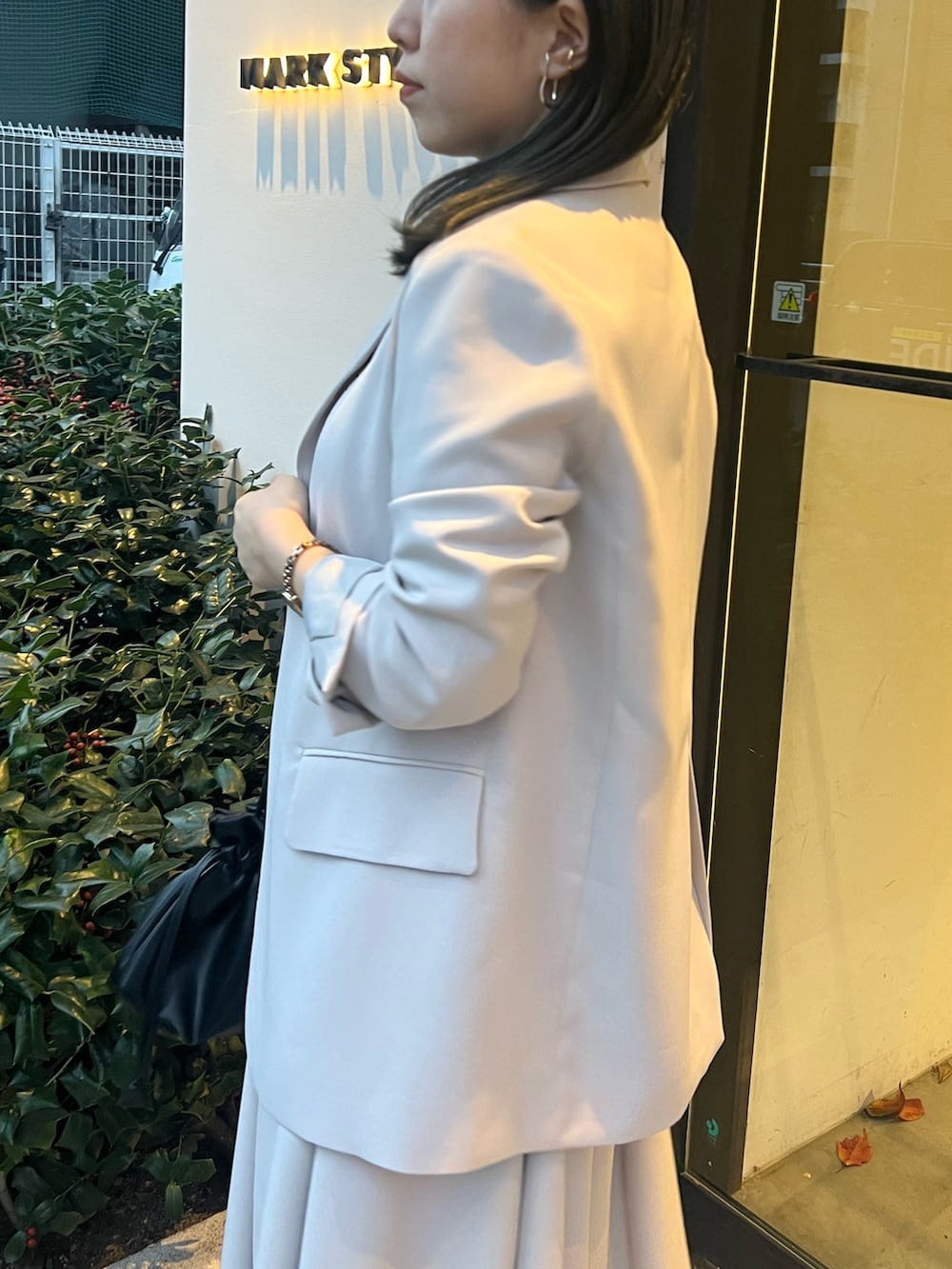 ベージュ系のテーラードジャケット、ベージュ系のワンピース、ブラック系のブーツを着用したレディースの冬コーディネートの5枚目の写真