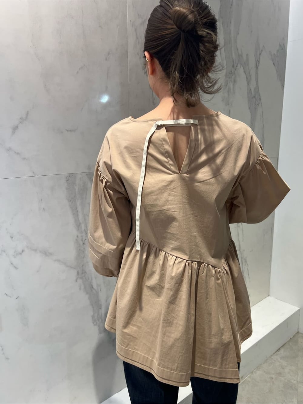 ベージュ系のシャツ/ブラウス、シルバー系のトートバッグ、ブルー系のスラックスを着用したレディースの冬コーディネートの5枚目の写真