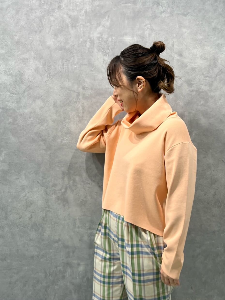 ブラウン系のブーツ、グリーン系のその他パンツ、オレンジ系のニット/セーターを着用したレディースの冬コーディネートの4枚目の写真