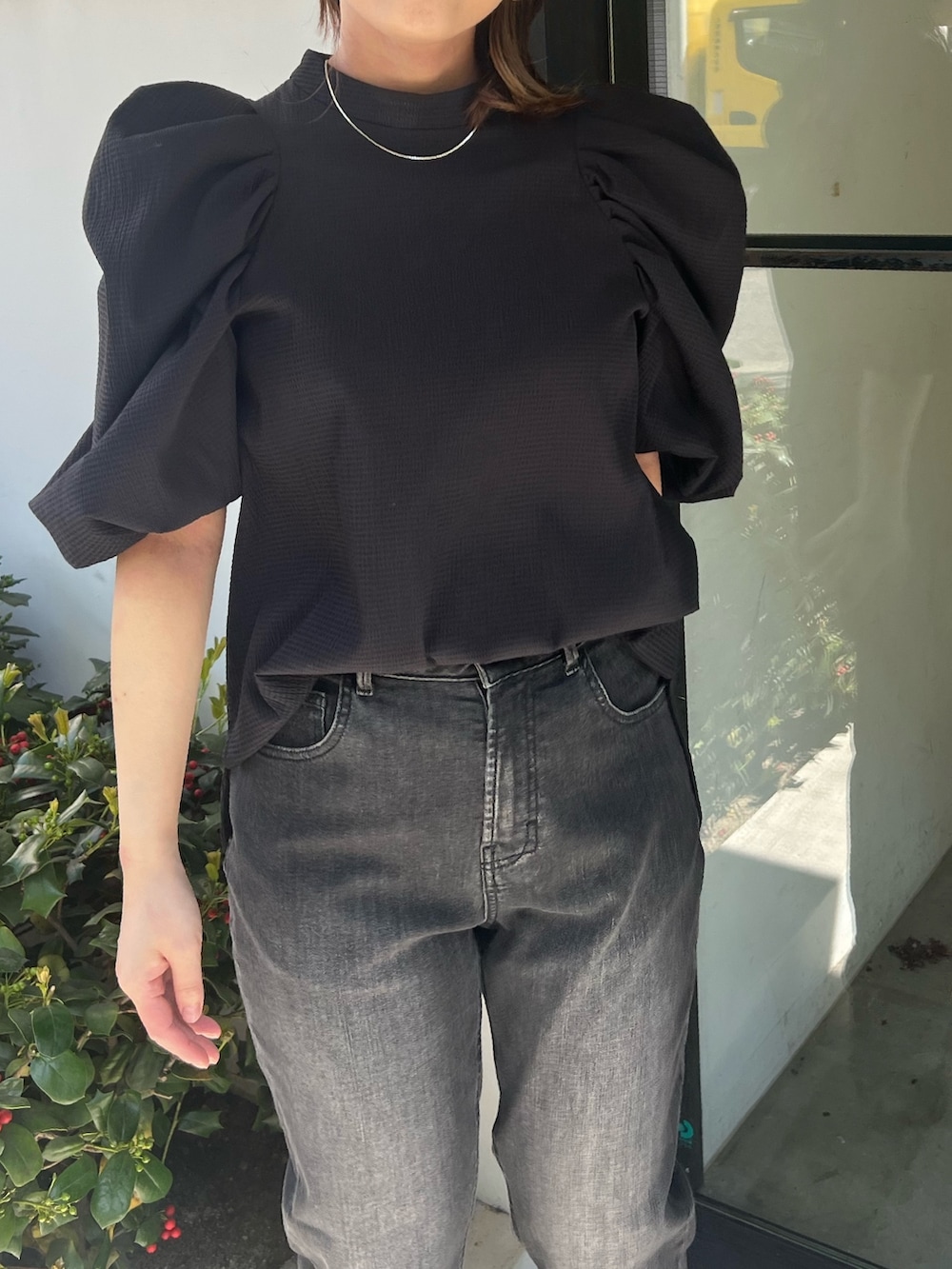 ブラック系のシャツ/ブラウス、グレー系のデニムパンツ、ブラック系のパンプスを着用したレディースの春コーディネートの2枚目の写真