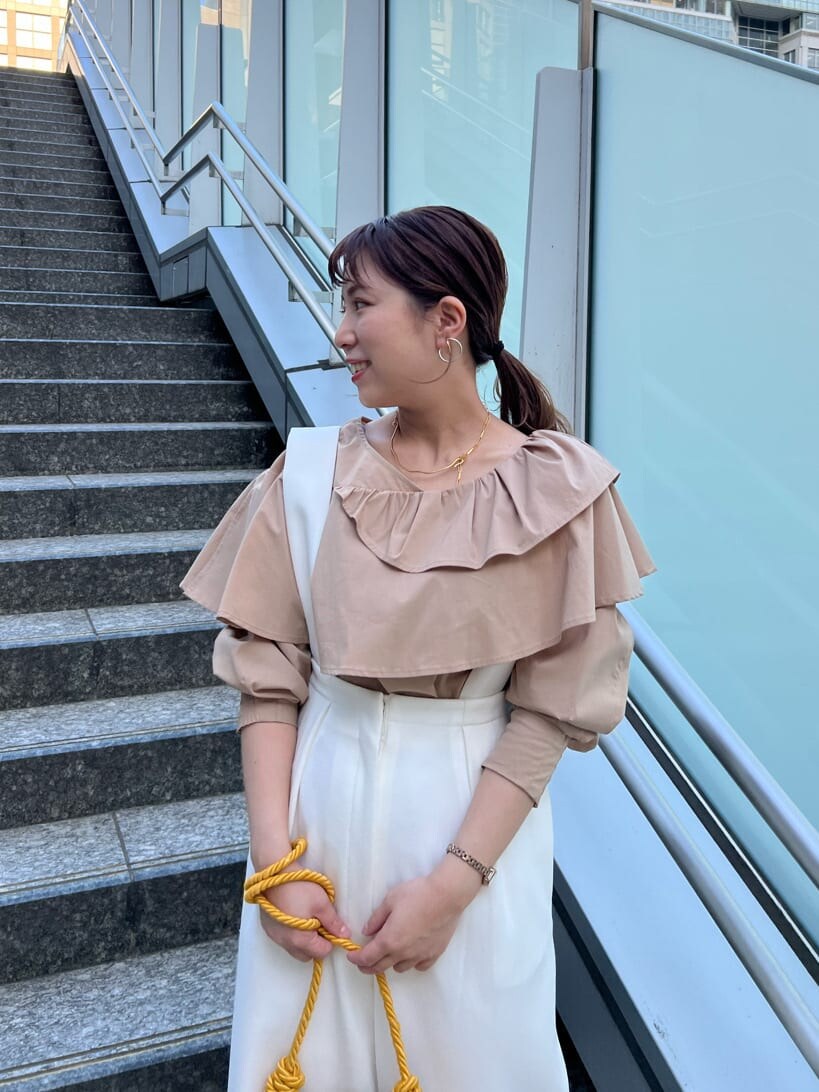 ホワイト系のスラックス、ベージュ系のシャツ/ブラウスを着用したレディースの春コーディネートの3枚目の写真