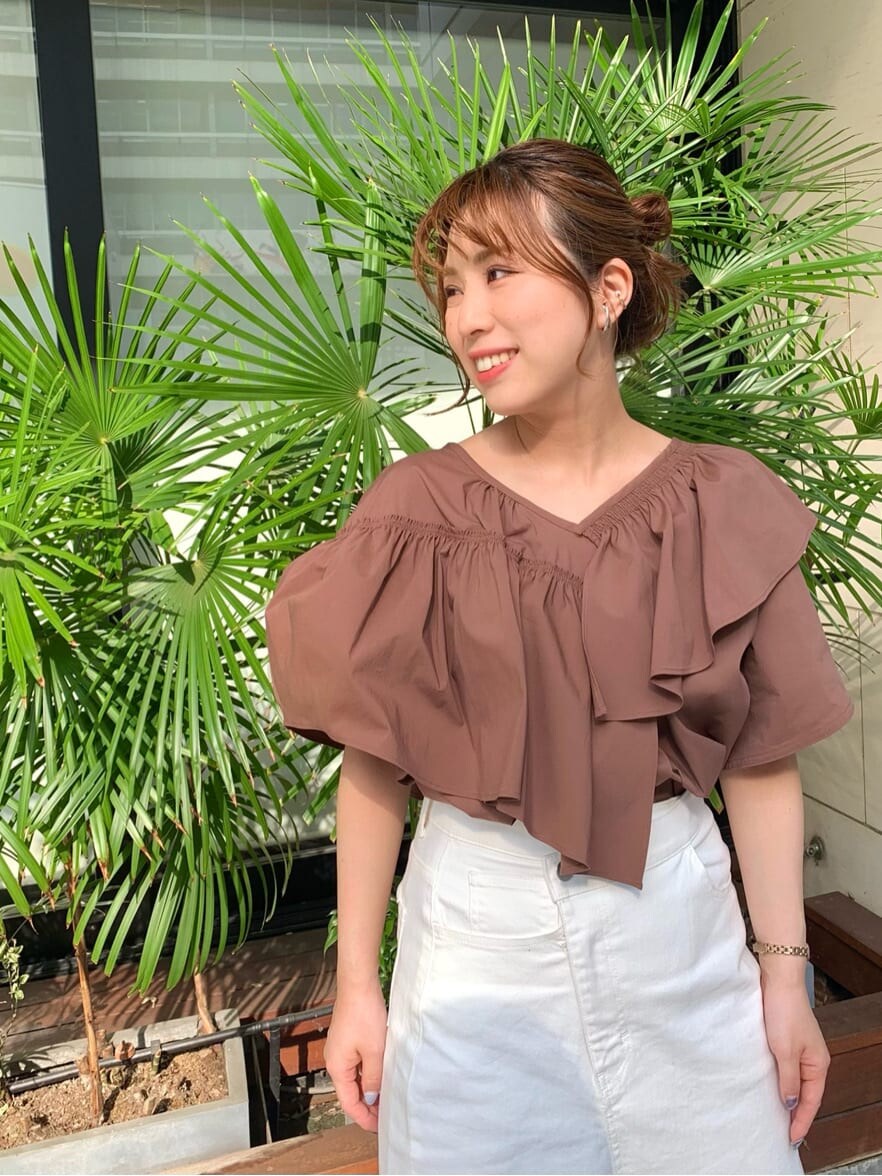 ホワイト系のデニムスカート、ベージュ系のサンダル、ホワイト系のハンドバッグを着用したレディースの夏コーディネートの5枚目の写真