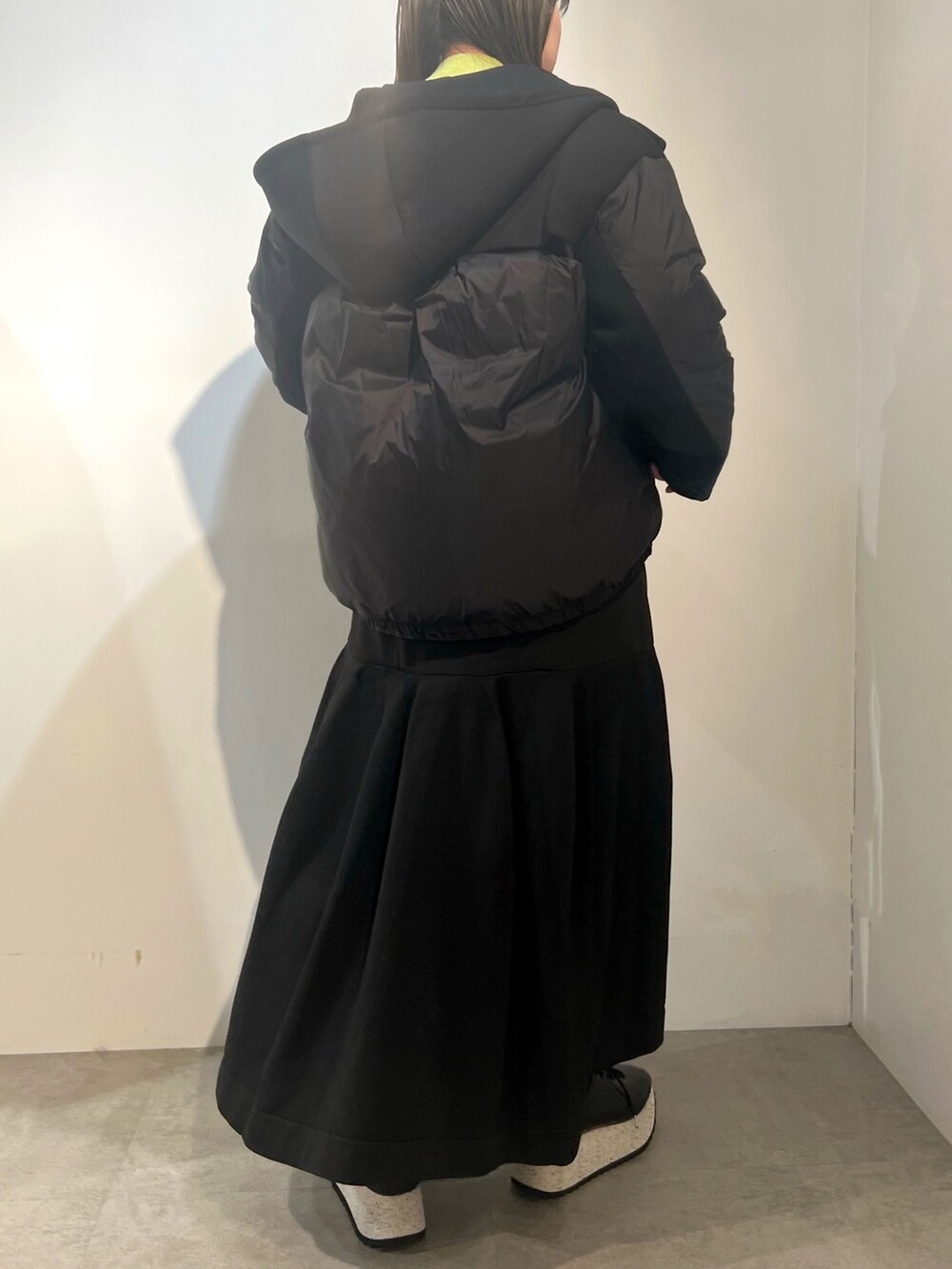 ブラック系のダウンジャケット/コート、グリーン系のニット/セーター、ブラック系のワンピースを着用したレディースの冬コーディネートの4枚目の写真