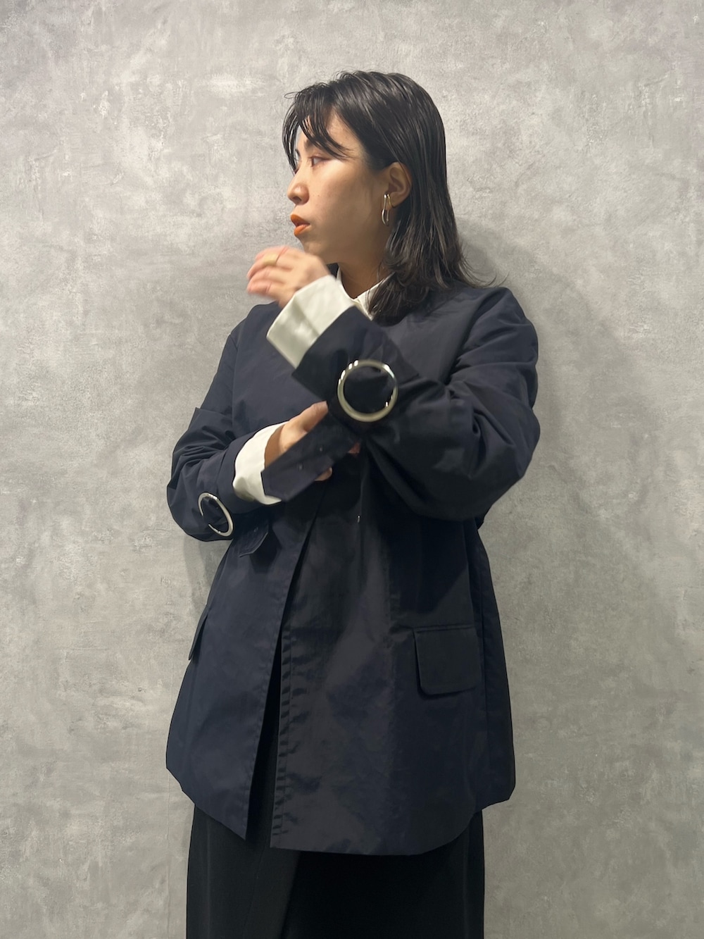 ブルー系のノーカラージャケット、ホワイト系のシャツ/ブラウス、ブラック系のスカートを着用したレディースの春コーディネートの3枚目の写真