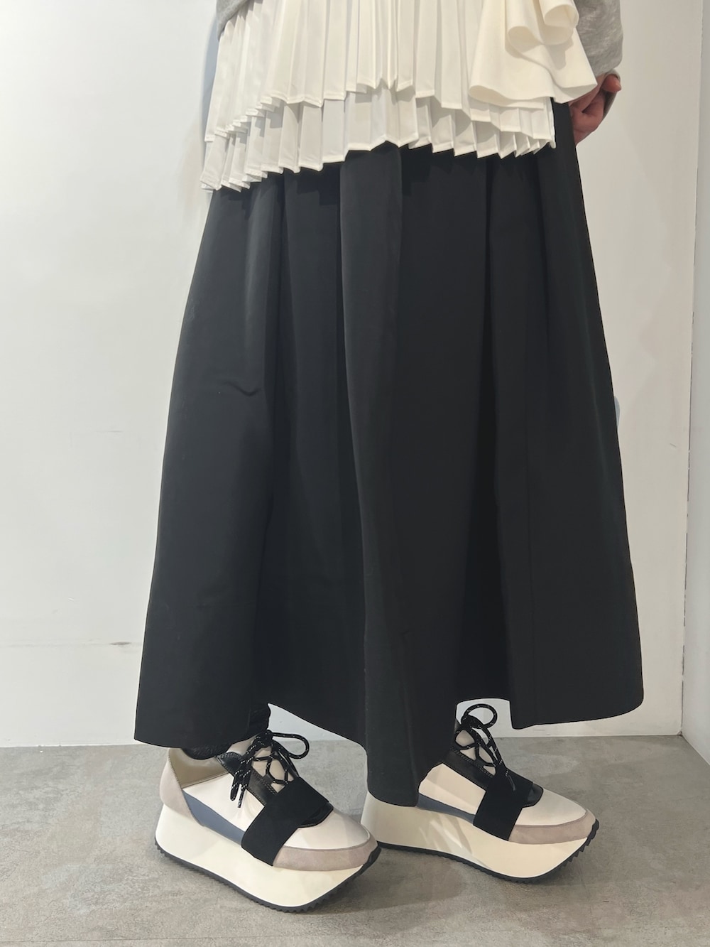 グレー系のTシャツ/カットソー、ブラック系のスカート、ブルー系のスニーカーを着用したレディースの冬コーディネートの6枚目の写真