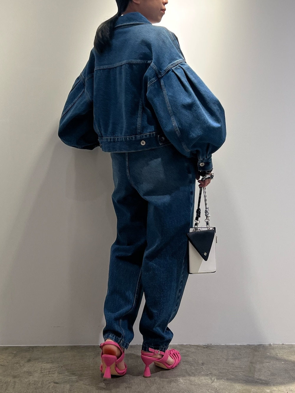 ブルー系のデニムジャケット、ブルー系のデニムパンツ、ブラック系のショルダーバッグを着用したレディースの冬コーディネートの3枚目の写真