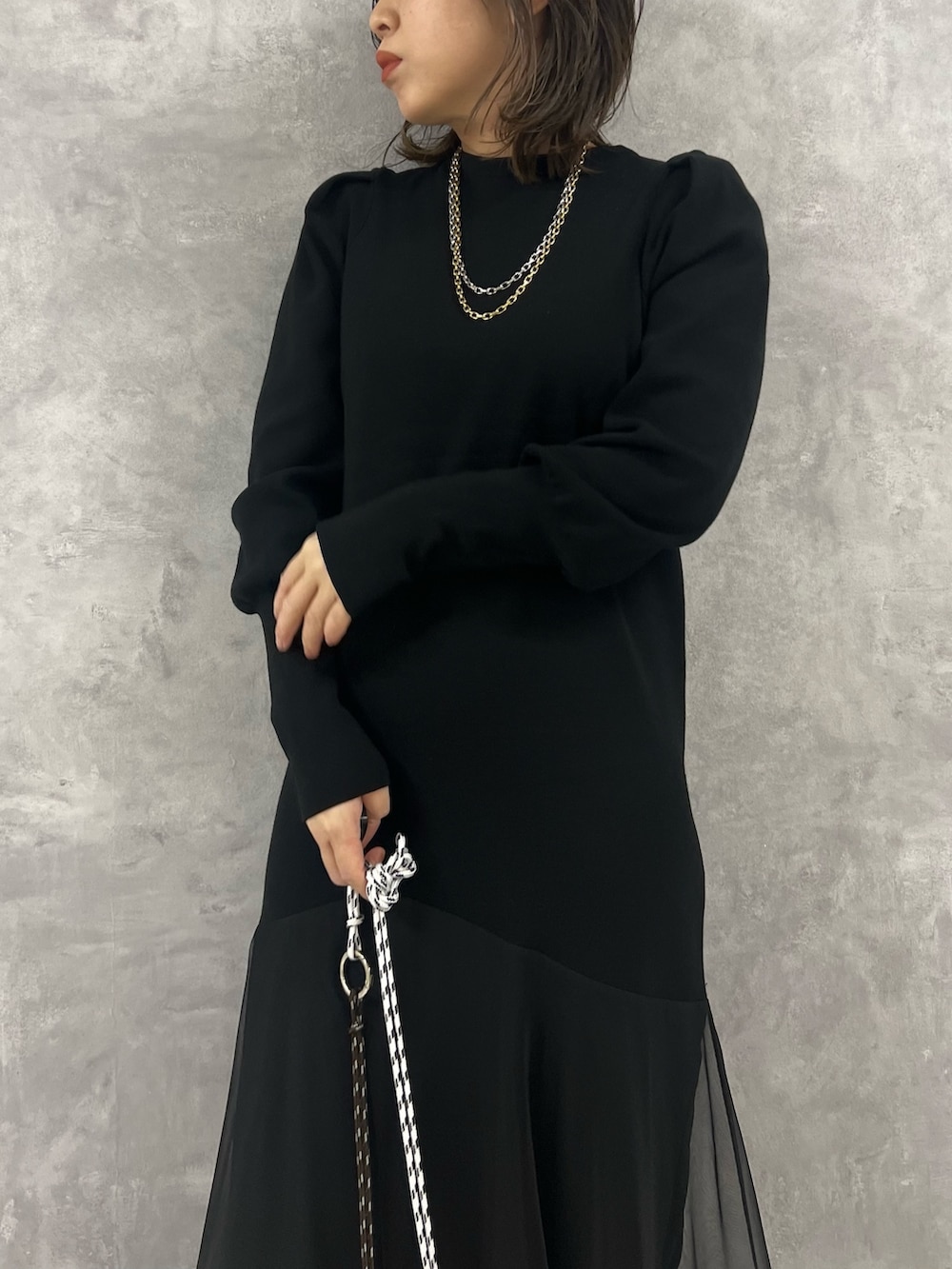 ブラック系のワンピース、ブルー系のデニムジャケット、ベージュ系のショルダーバッグを着用したレディースの冬コーディネートの7枚目の写真