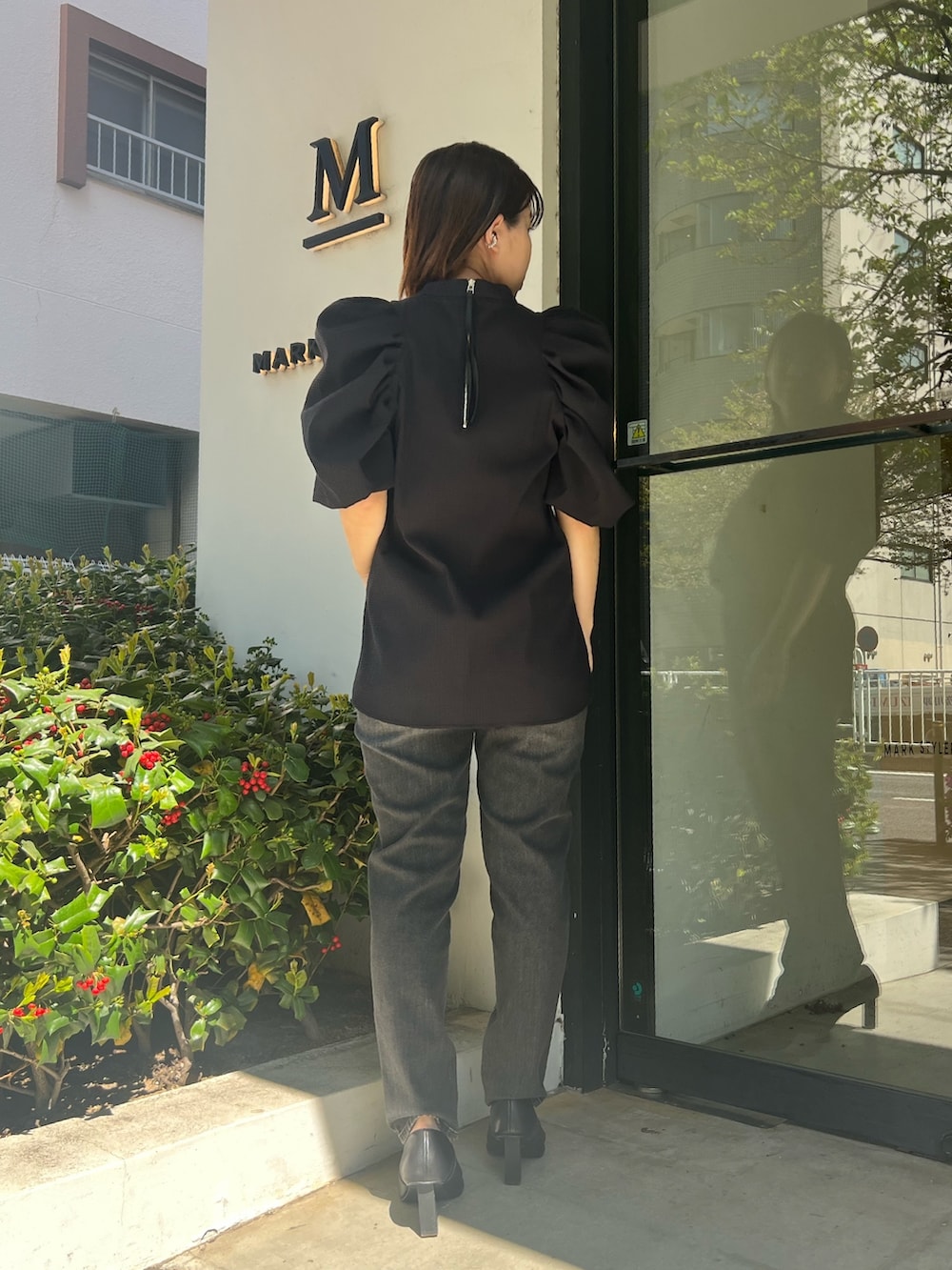 ブラック系のシャツ/ブラウス、グレー系のデニムパンツ、ブラック系のパンプスを着用したレディースの春コーディネートの5枚目の写真