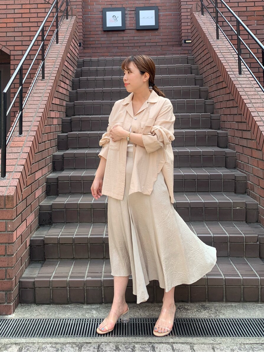 ブラウン系のスカート、ベージュ系のシャツ/ブラウスを着用したレディースの春コーディネートの2枚目の写真