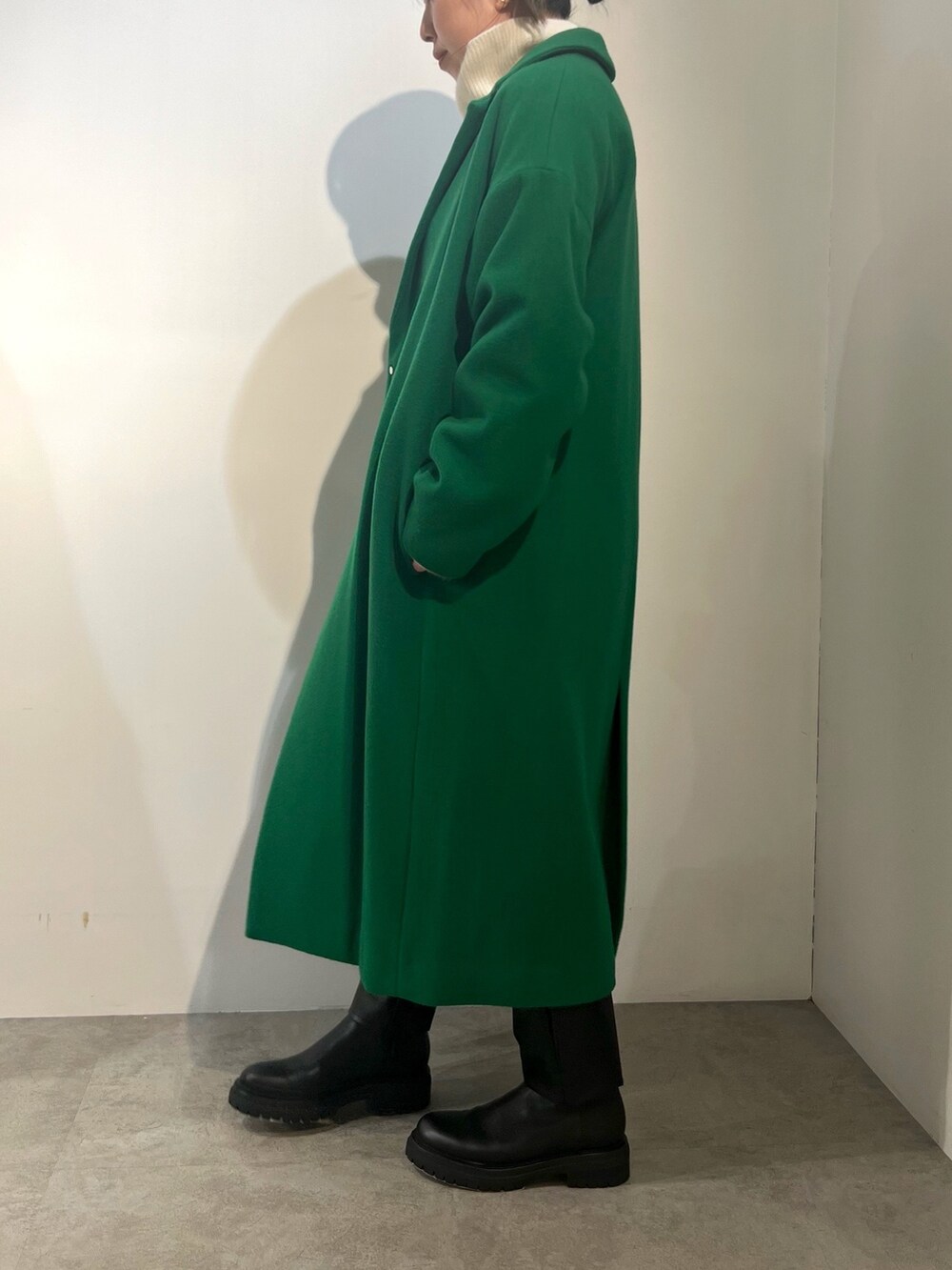 ブラック系のその他パンツ、ホワイト系のニット/セーター、グリーン系のチェスターコートを着用したレディースの冬コーディネートの2枚目の写真