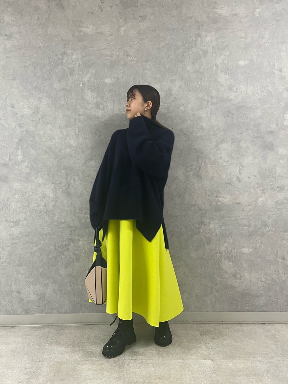 ブルー系のニット/セーター、ベージュ系のハンドバッグ、イエロー系のスカートを着用したレディースの秋コーディネートの8枚目の写真