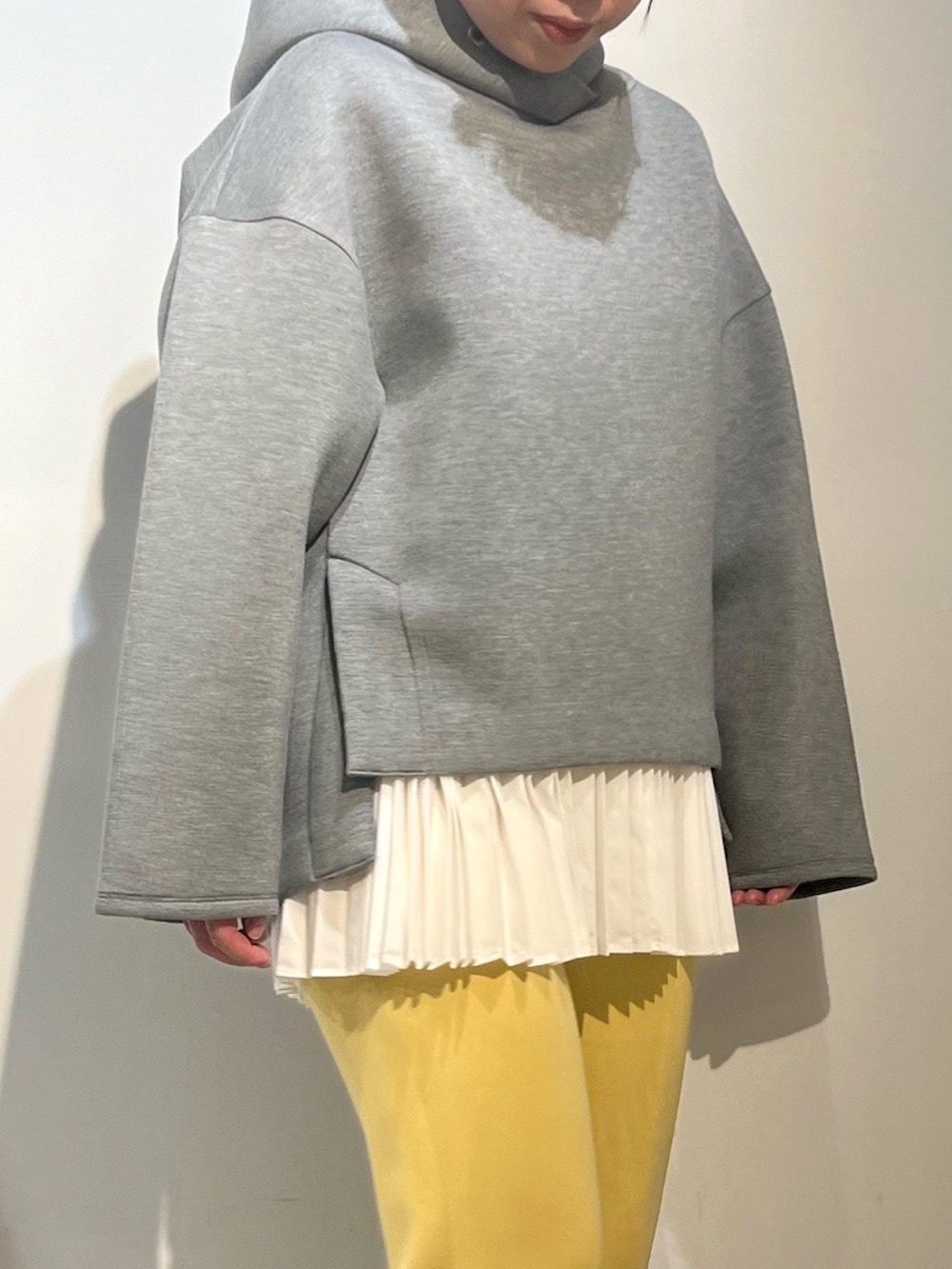 ホワイト系のスニーカー、グレー系のパーカー、イエロー系のその他パンツを着用したレディースの冬コーディネートの4枚目の写真