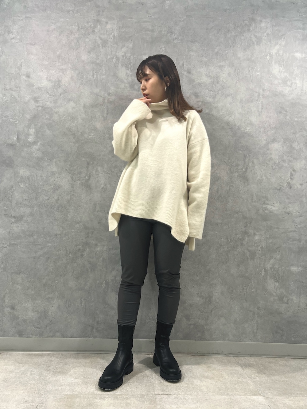 グリーン系のノーカラーコート、ホワイト系のニット/セーター、グレー系のその他パンツを着用したレディースの秋コーディネートの5枚目の写真