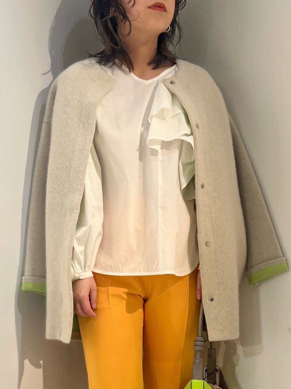 ホワイト系のシャツ/ブラウス、ホワイト系のカーディガン/ボレロ、イエロー系のハンドバッグを着用したレディースの冬コーディネートの5枚目の写真