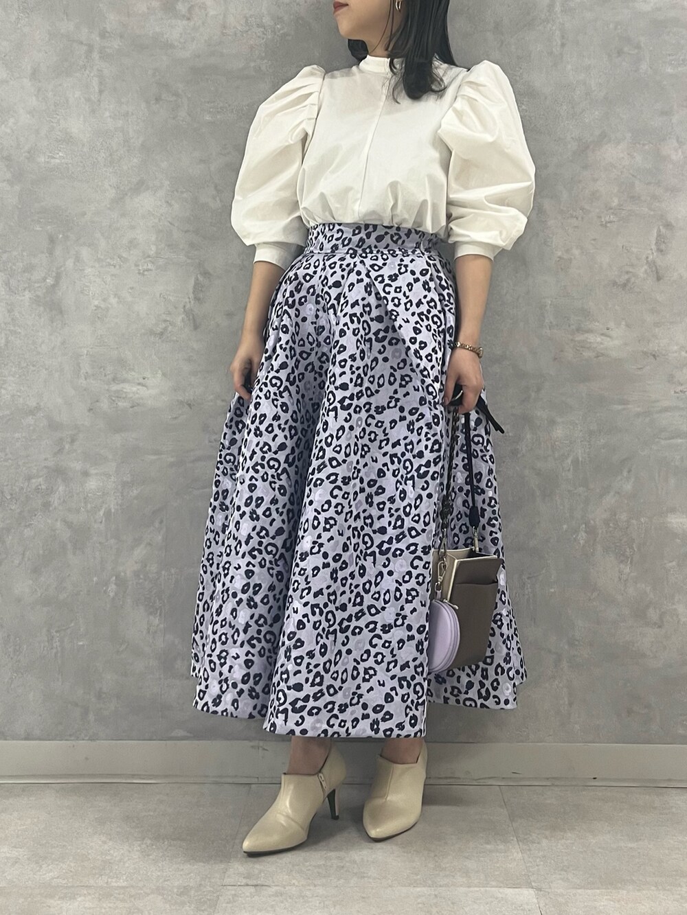 ホワイト系のシャツ/ブラウス、ベージュ系のスカート、ベージュ系のショルダーバッグを着用したレディースの冬コーディネートの3枚目の写真