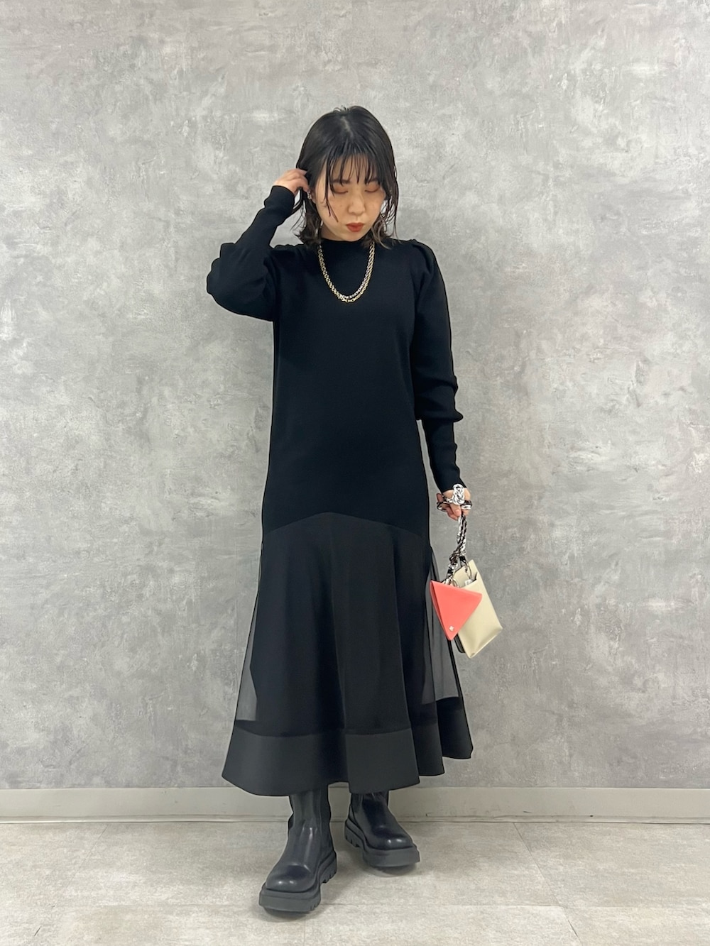 ブラック系のワンピース、ブルー系のデニムジャケット、ベージュ系のショルダーバッグを着用したレディースの冬コーディネートの5枚目の写真