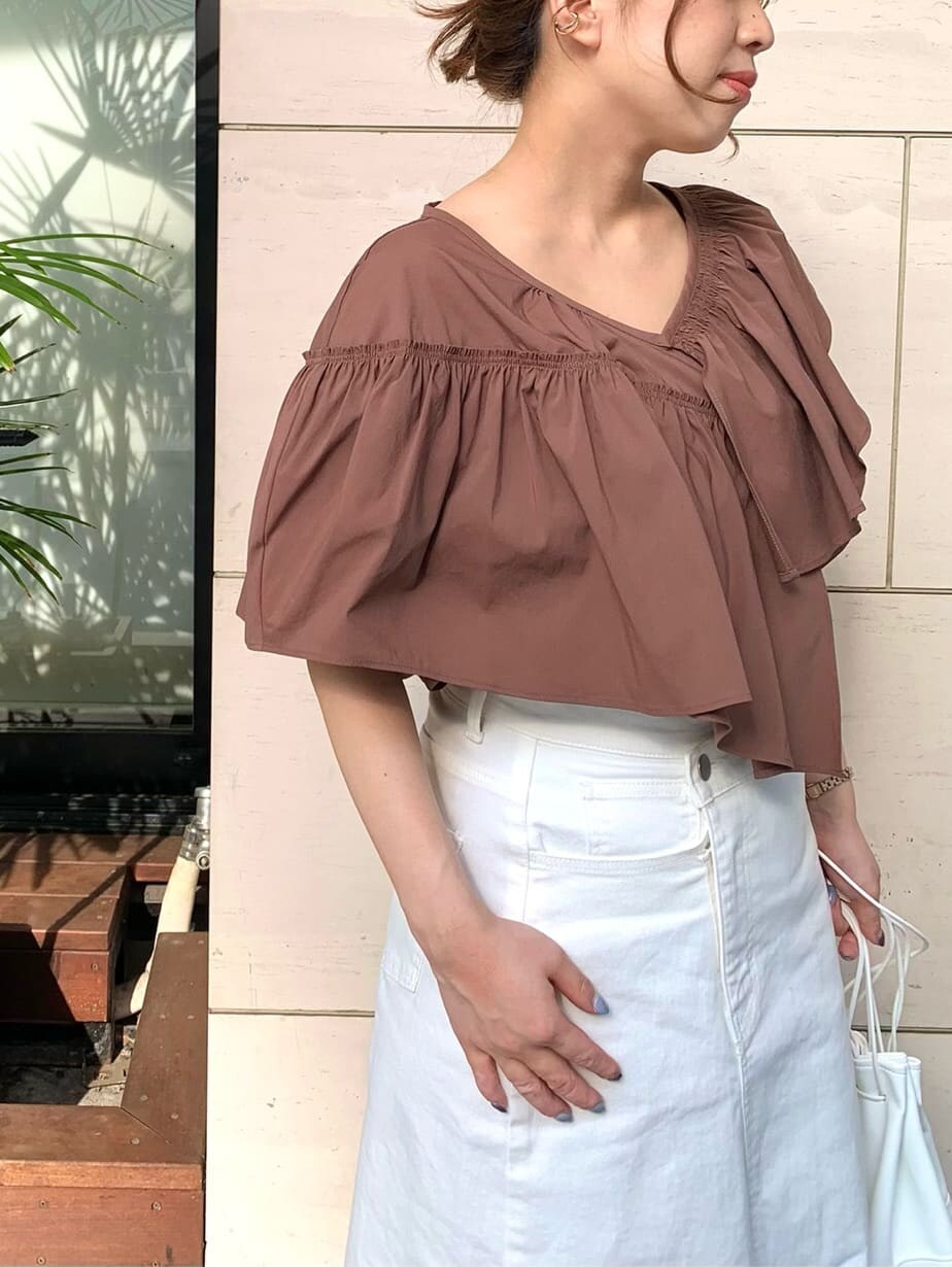 ホワイト系のデニムスカート、ベージュ系のサンダル、ホワイト系のハンドバッグを着用したレディースの夏コーディネートの6枚目の写真