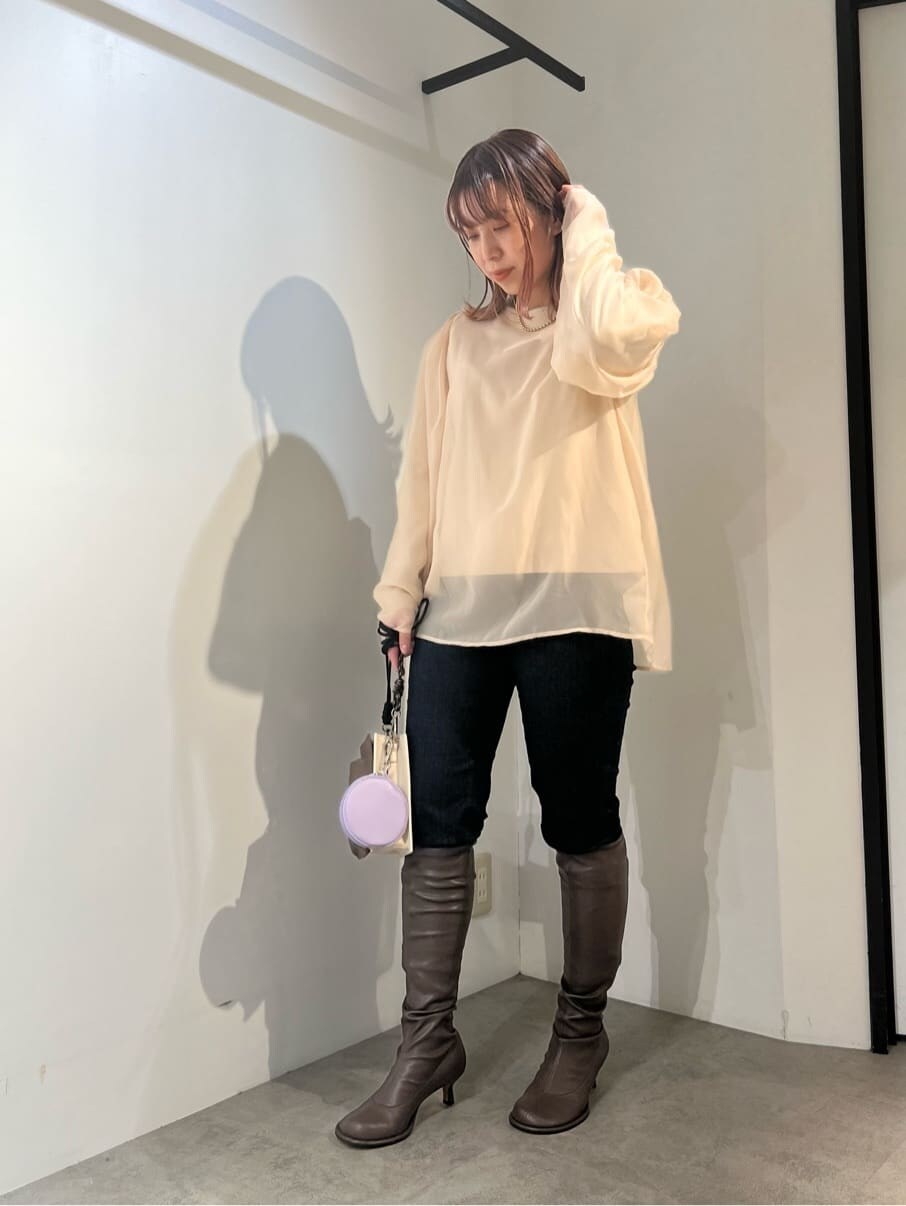 ブルー系のデニムパンツ、ベージュ系のショルダーバッグ、ブラウン系のニット/セーターを着用したレディースの秋コーディネートの2枚目の写真