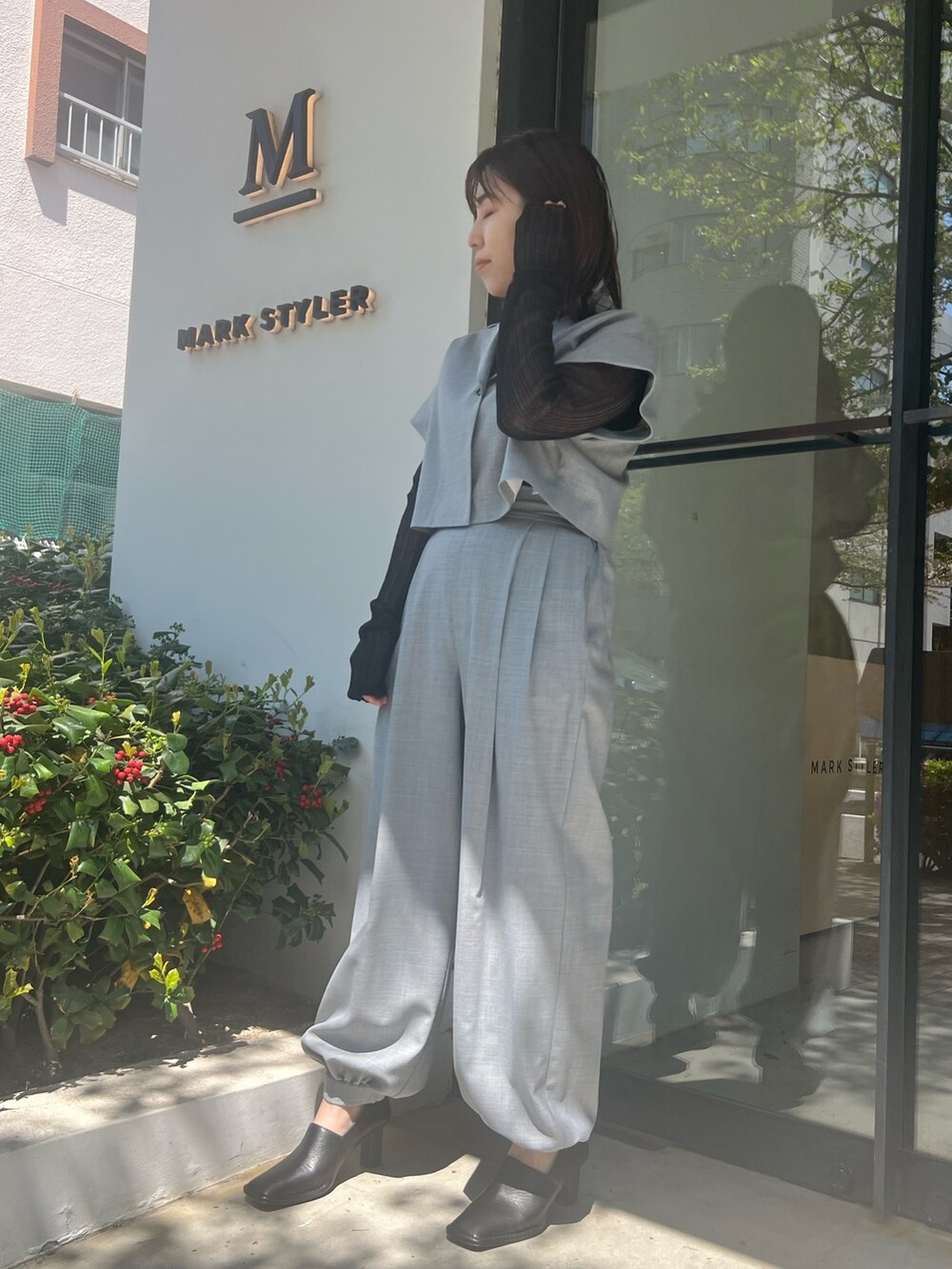 グレー系のテーラードジャケット、グレー系のスラックス、ブラック系のパンプスを着用したレディースの春コーディネートの2枚目の写真