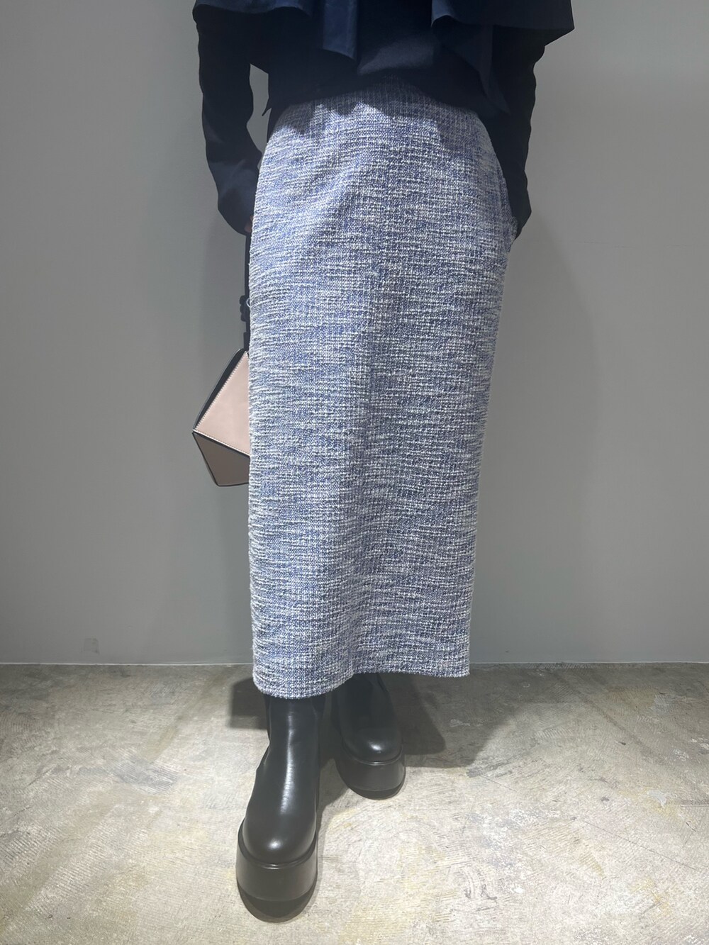 ブラック系のブーツ、ブルー系のニット/セーター、ブルー系のスカートを着用したレディースの春コーディネートの5枚目の写真