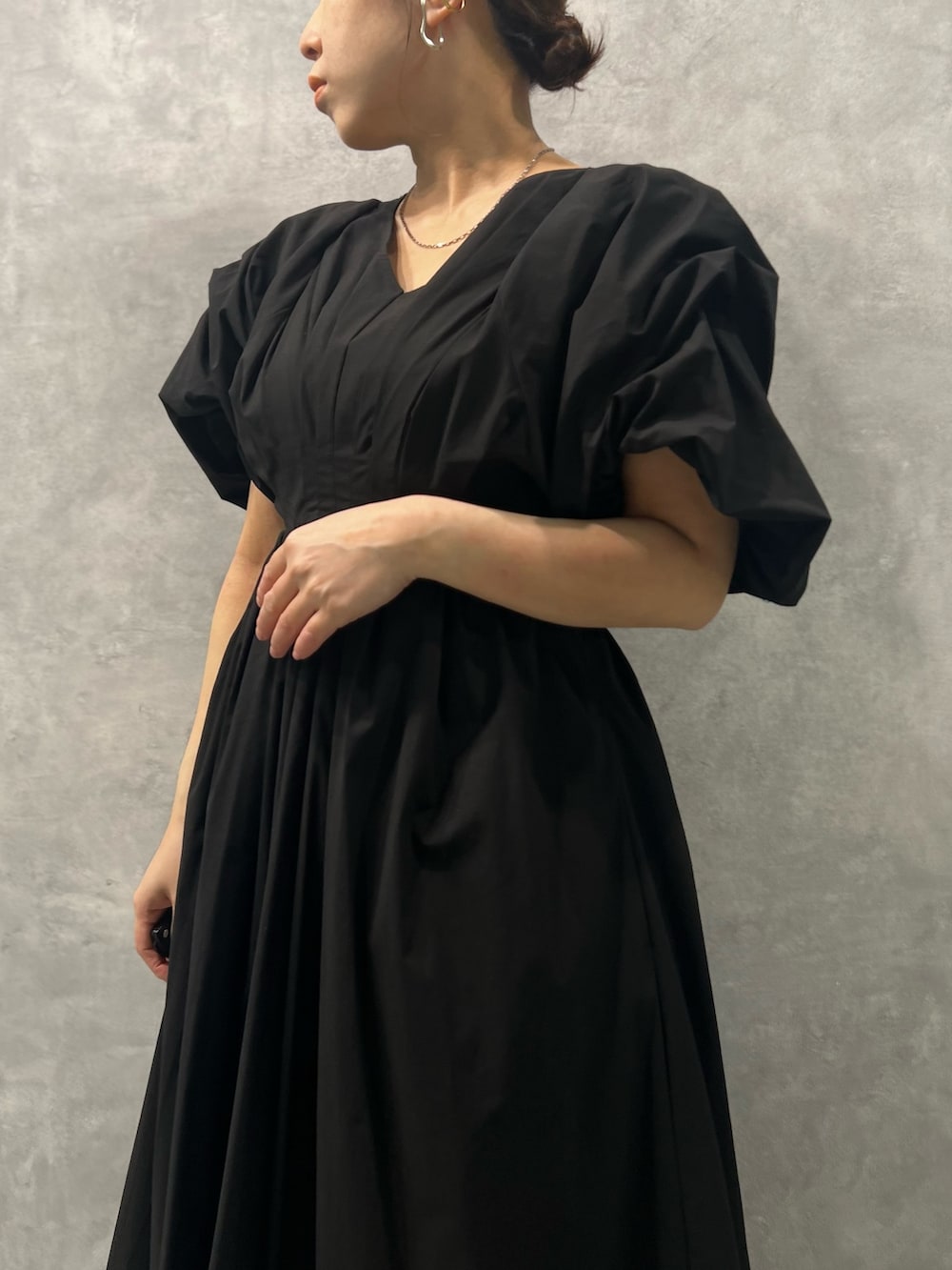 ブラック系のワンピース、ブラック系のサンダル、シルバー系のネックレスを着用したレディースの春コーディネートの4枚目の写真