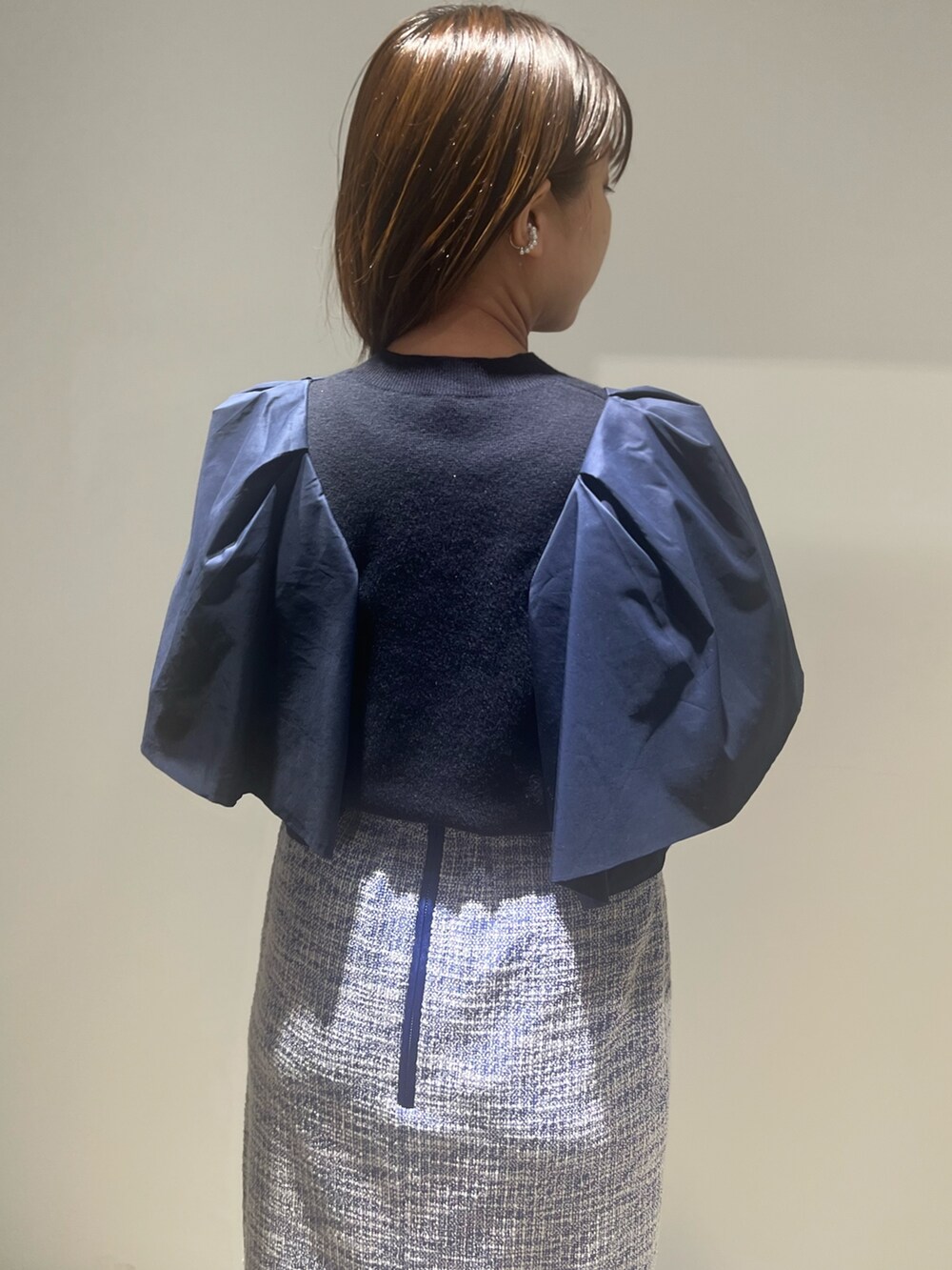 ブラック系のブーツ、ブルー系のニット/セーター、ブルー系のスカートを着用したレディースの春コーディネートの4枚目の写真