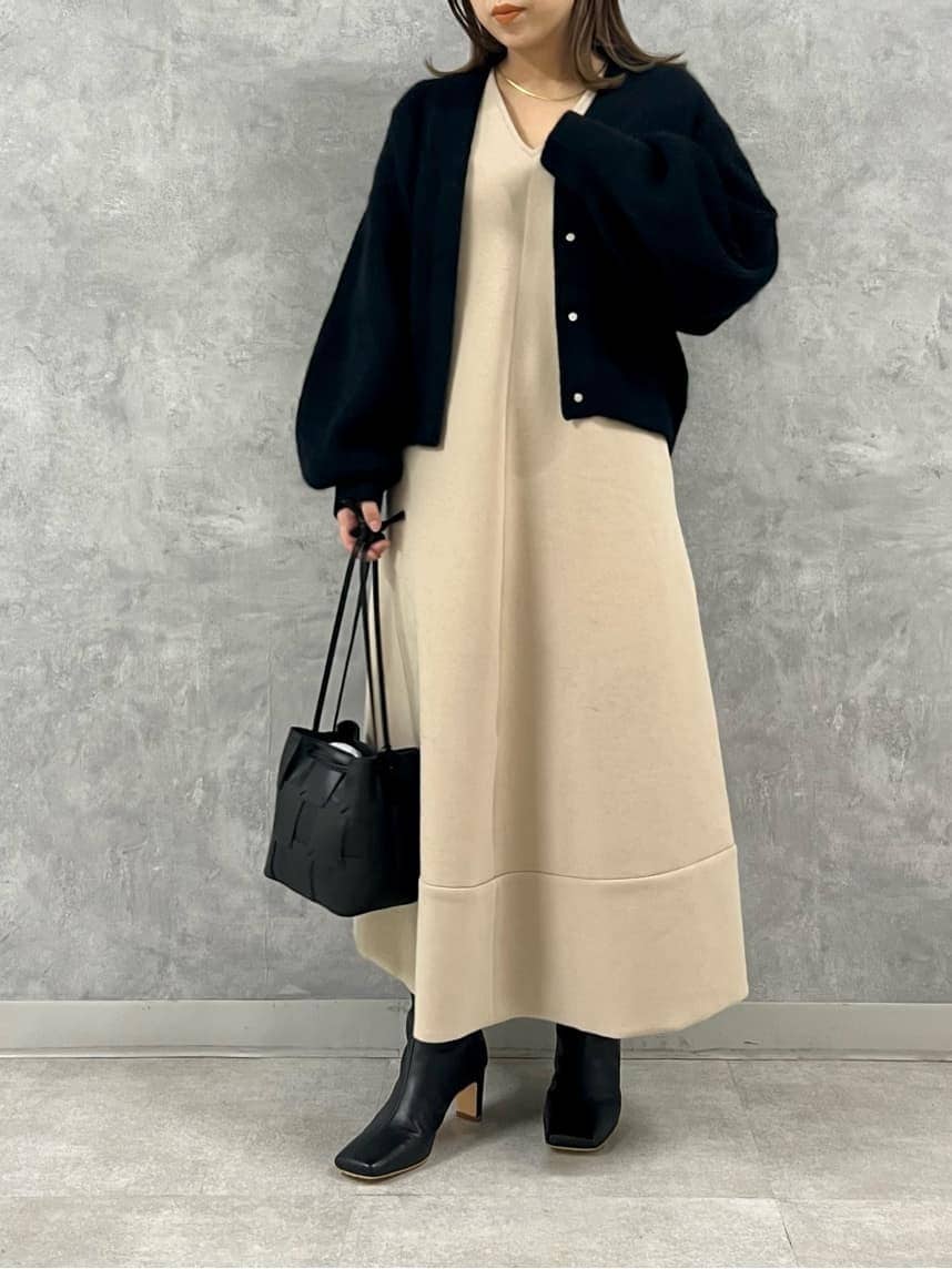 ブラック系のブーツ、ブラック系のカーディガン/ボレロ、ベージュ系のワンピースを着用したレディースの秋コーディネートの2枚目の写真