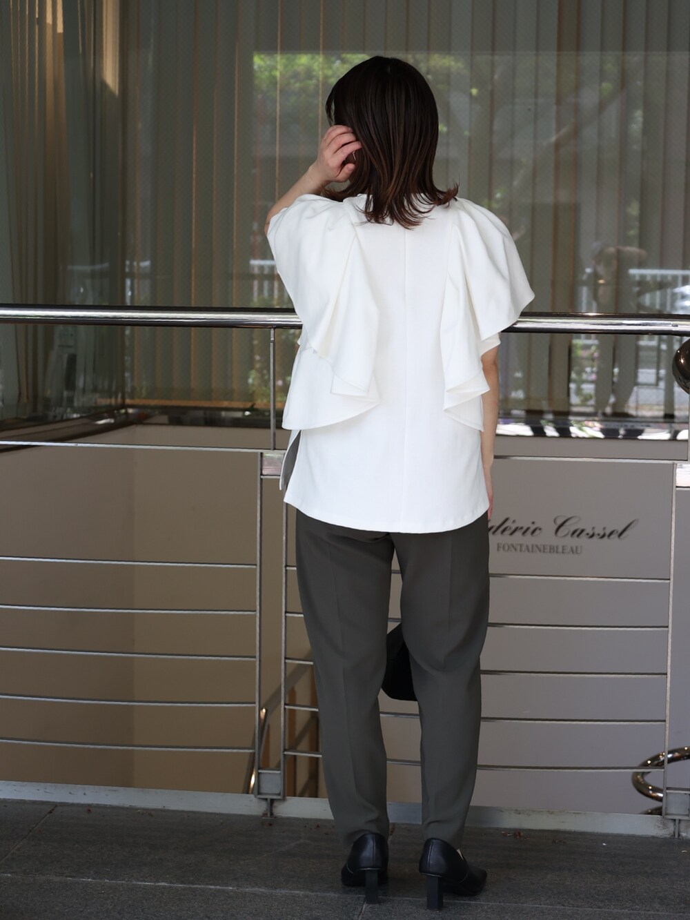 ホワイト系のTシャツ/カットソー、ブラック系のハンドバッグ、ブラック系のパンプスを着用したレディースの夏コーディネートの3枚目の写真