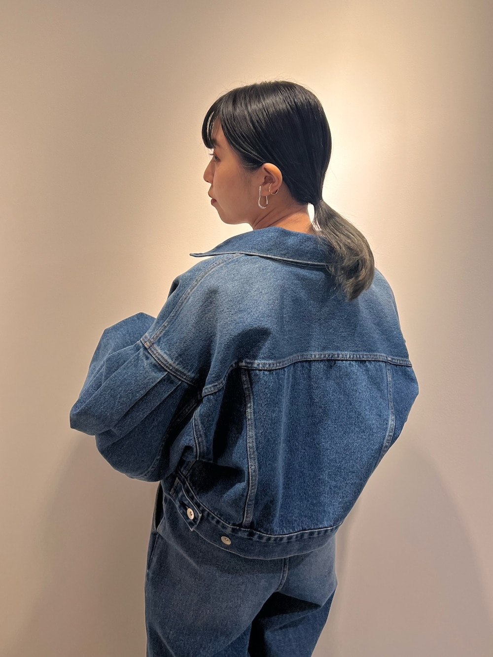 ブルー系のデニムジャケット、ブルー系のデニムパンツ、ブラック系のショルダーバッグを着用したレディースの冬コーディネートの4枚目の写真