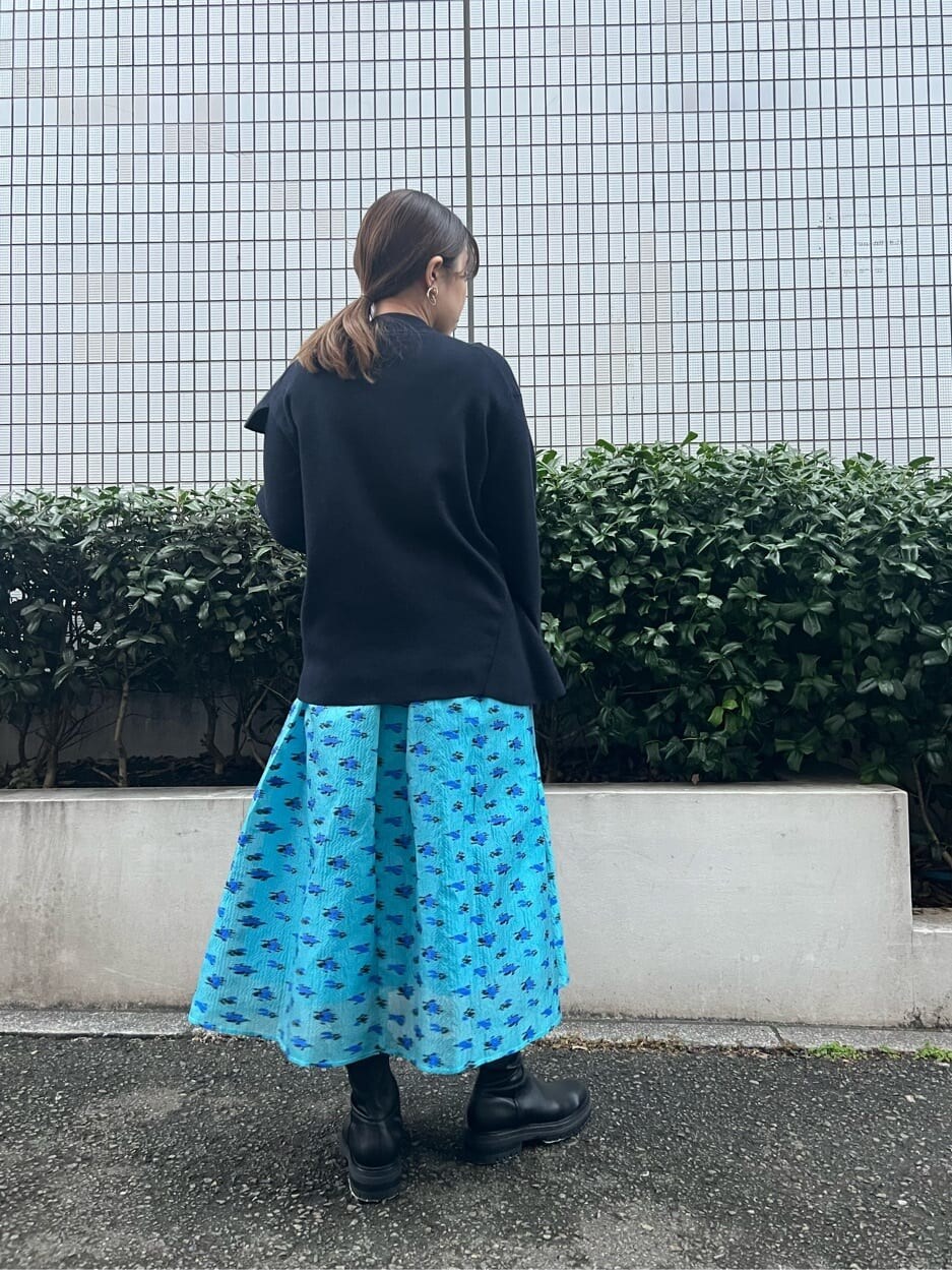 ブルー系のスカート、ブルー系のニット/セーターを着用したレディースの秋コーディネートの2枚目の写真