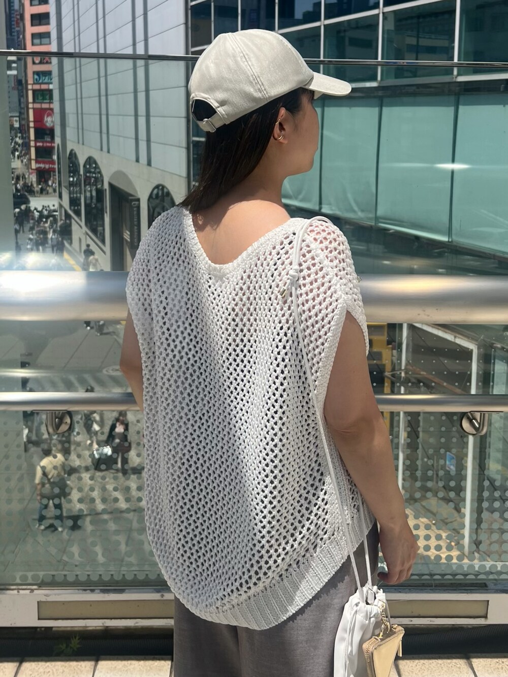 ホワイト系のニット/セーター、ブラウン系のその他パンツ、ホワイト系のショルダーバッグを着用したレディースの夏コーディネートの5枚目の写真