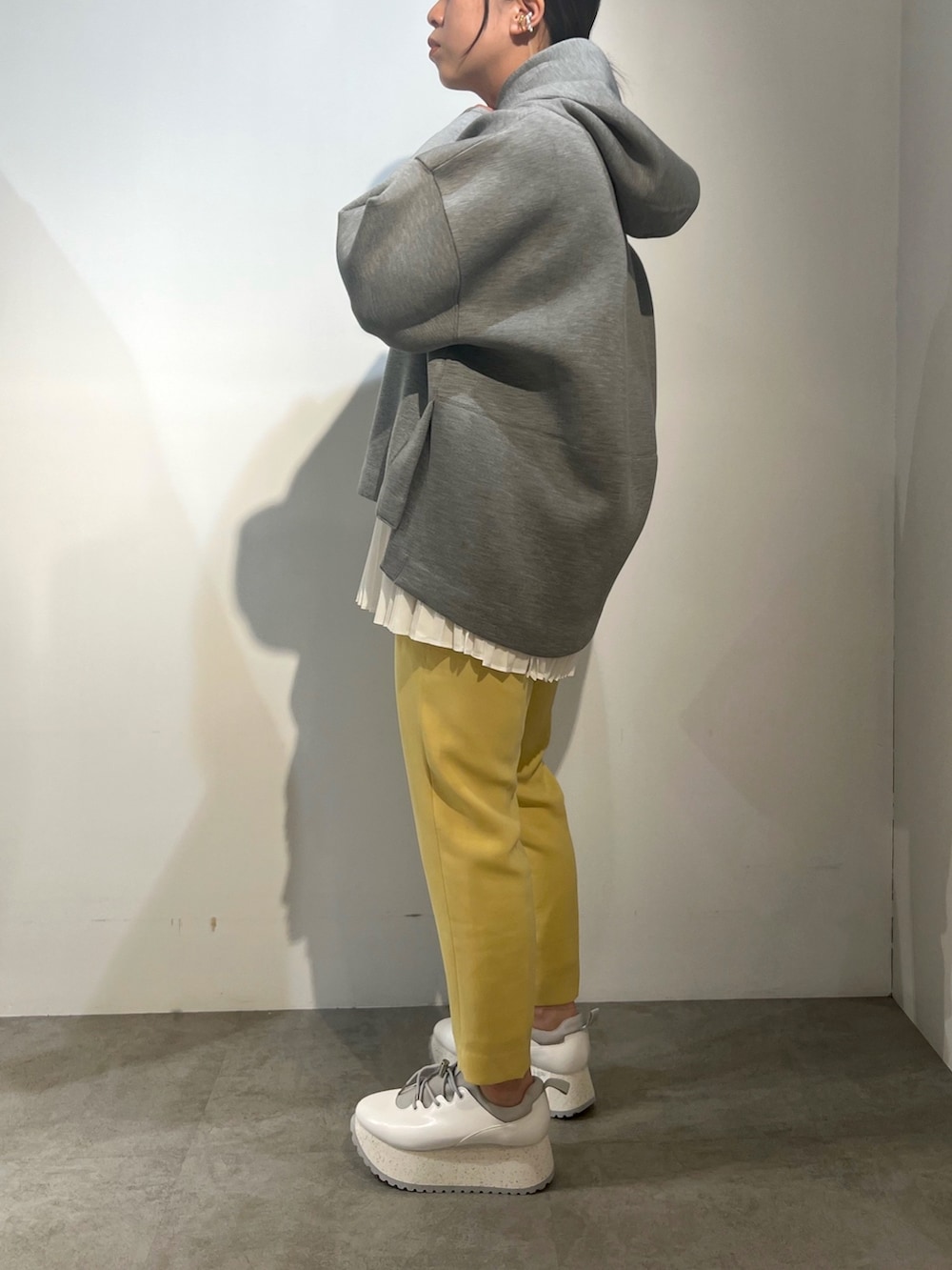 ホワイト系のスニーカー、グレー系のパーカー、イエロー系のその他パンツを着用したレディースの冬コーディネートの3枚目の写真