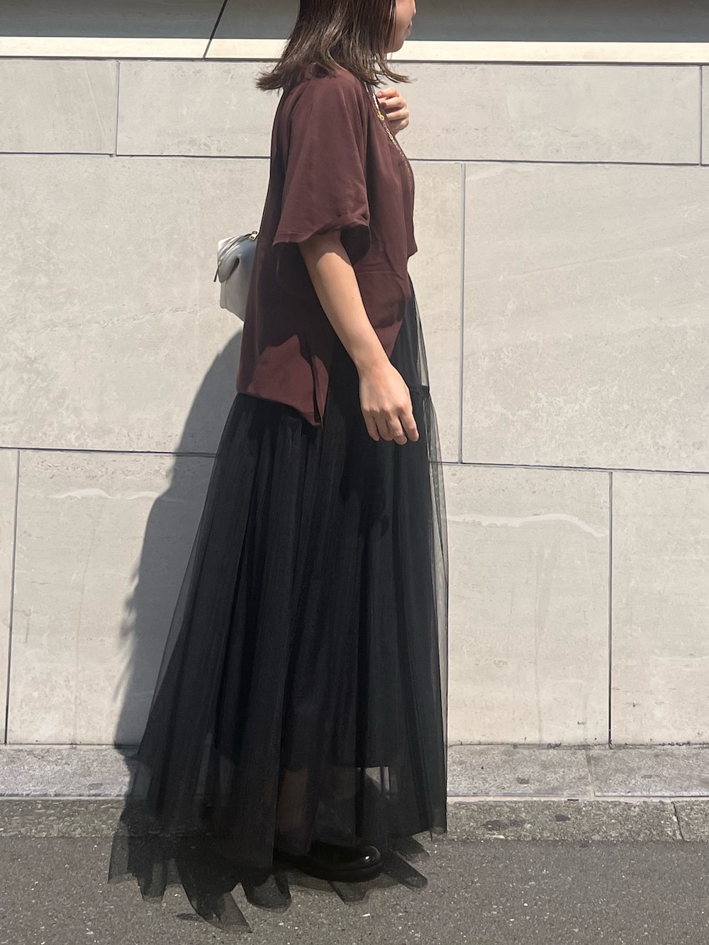 ブラック系のパンプス、ブラウン系のニット/セーター、ブラック系のスカートを着用したレディースの夏コーディネートの3枚目の写真
