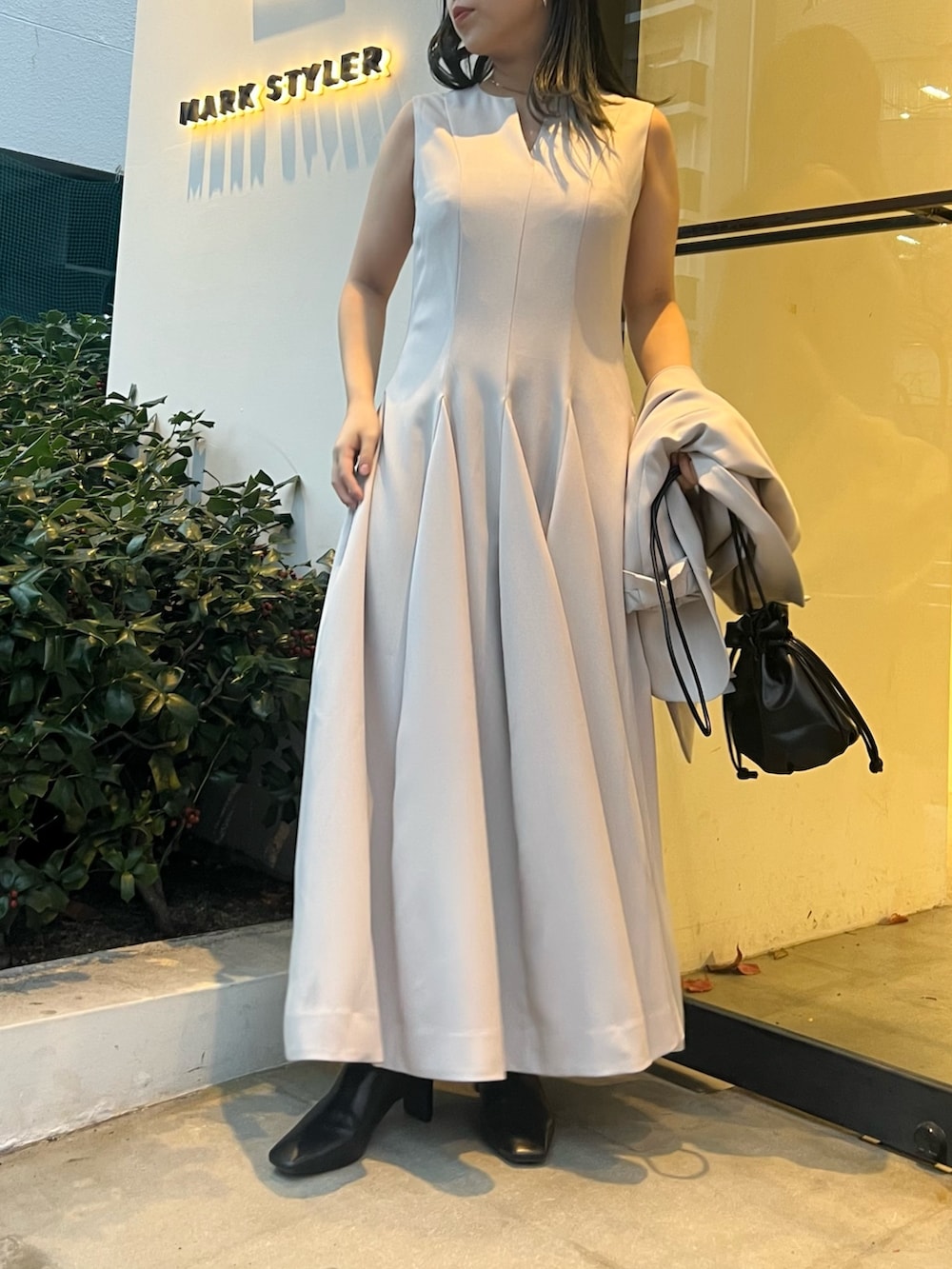 ベージュ系のテーラードジャケット、ベージュ系のワンピース、ブラック系のブーツを着用したレディースの冬コーディネートの6枚目の写真