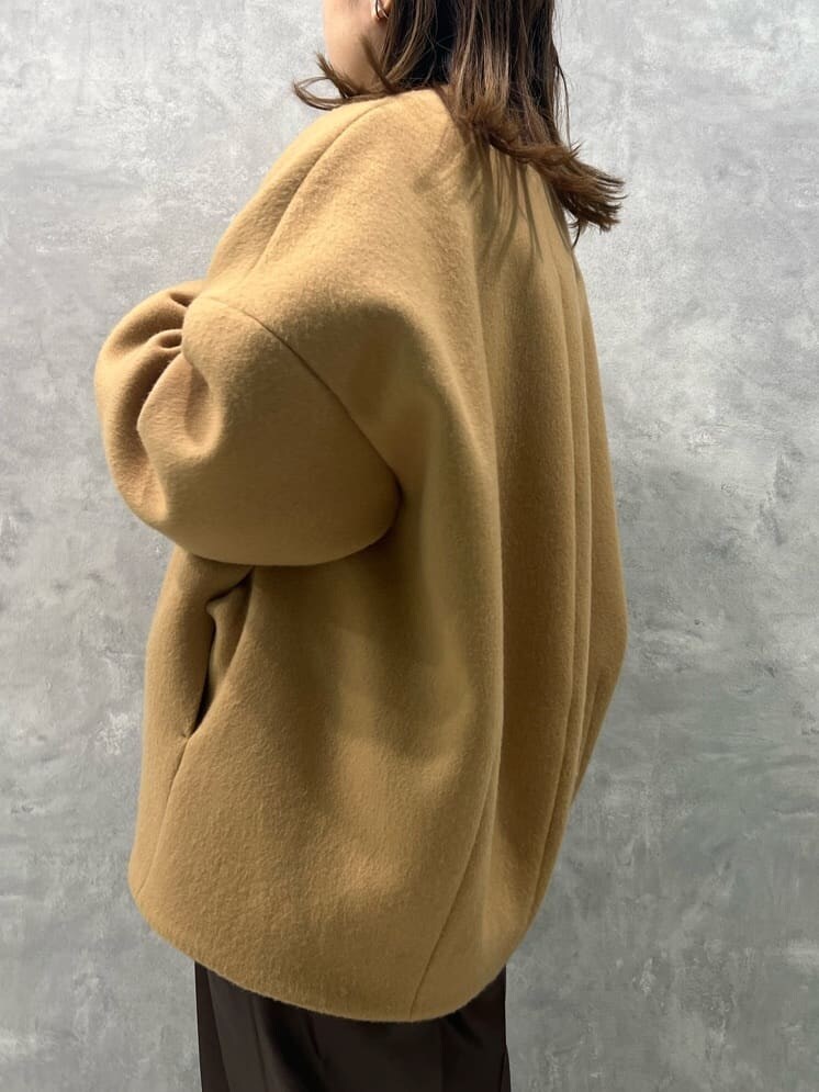 イエロー系のノーカラーコート、ブラウン系のその他パンツ、ホワイト系のニット/セーターを着用したレディースの秋コーディネートの6枚目の写真