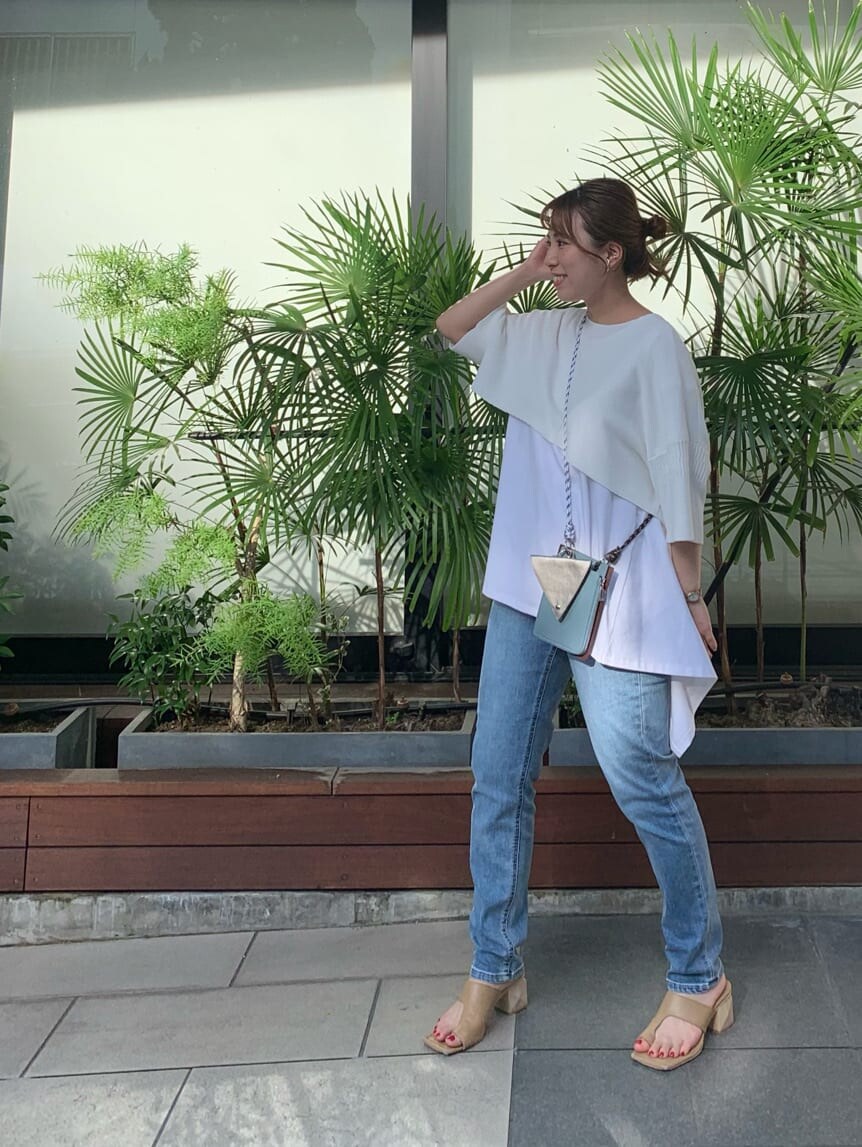 ブルー系のデニムパンツ、ホワイト系のTシャツ/カットソー、ベージュ系のサンダルを着用したレディースの夏コーディネートの2枚目の写真