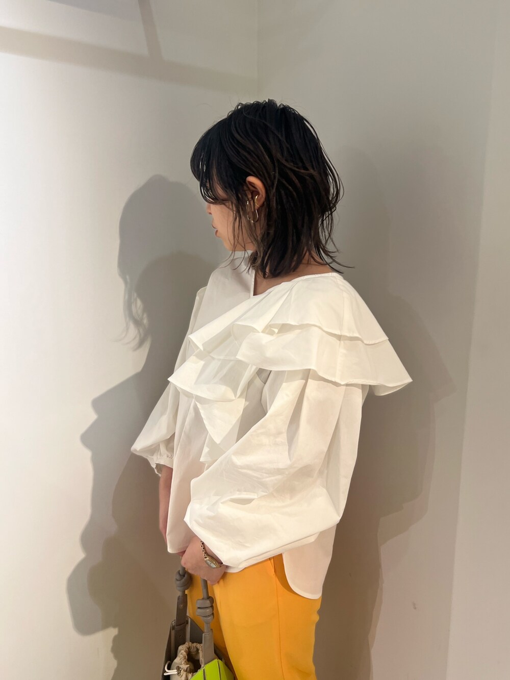 ホワイト系のシャツ/ブラウス、イエロー系のハンドバッグ、オレンジ系のその他パンツを着用したレディースの冬コーディネートの3枚目の写真