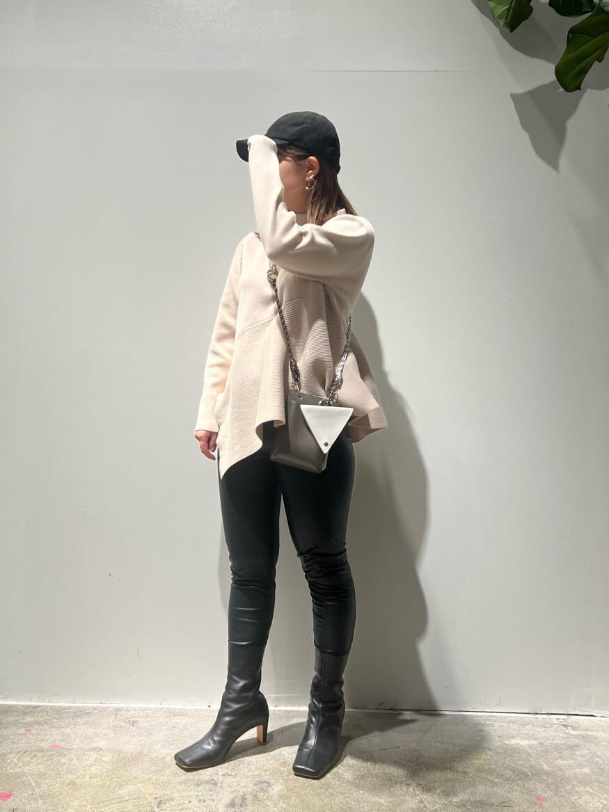 ブラック系のその他パンツ、ベージュ系のニット/セーター、ブラック系のブーツを着用したレディースの秋コーディネートの2枚目の写真