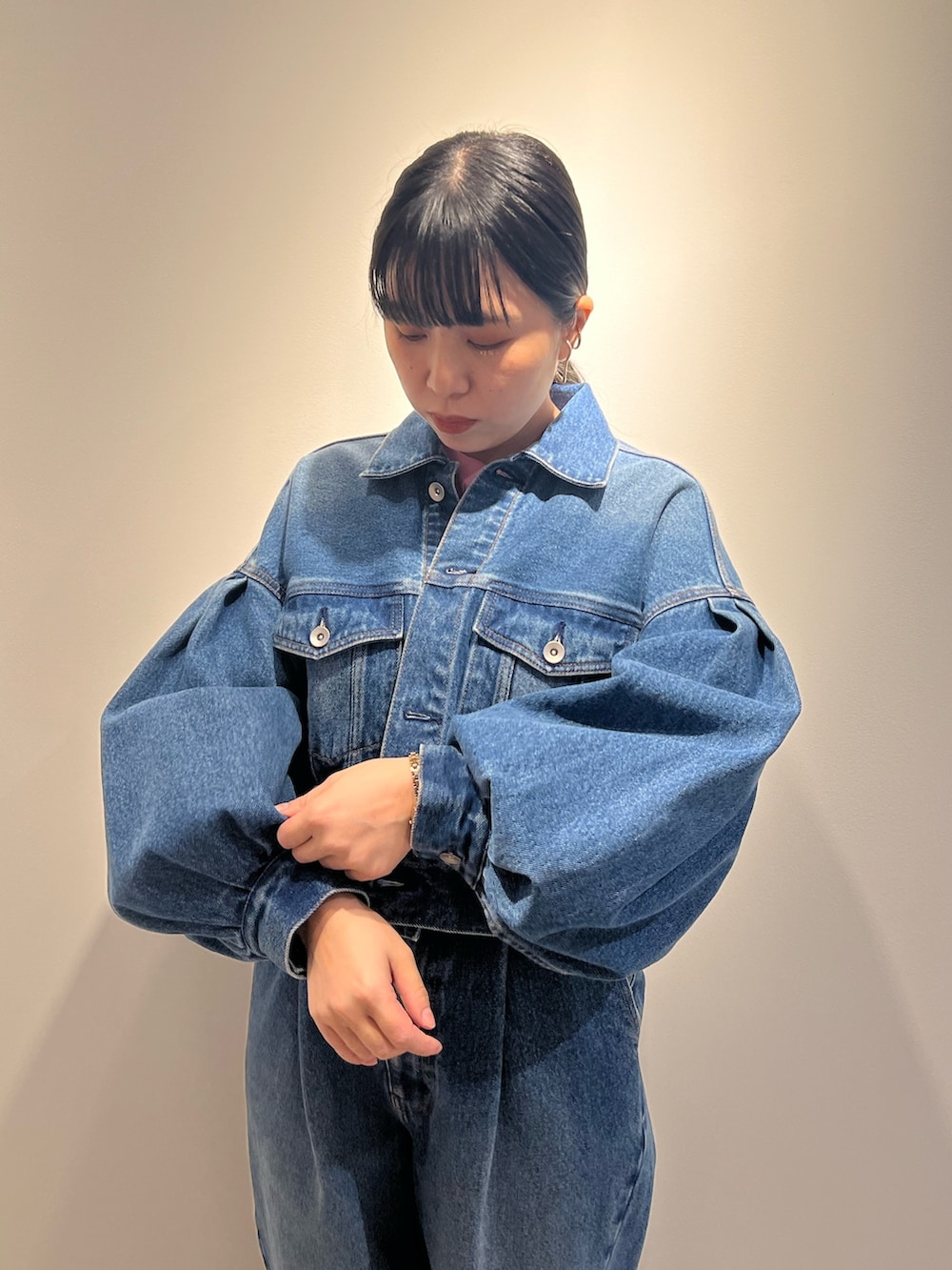 ブルー系のデニムジャケット、ブルー系のデニムパンツ、ブラック系のショルダーバッグを着用したレディースの冬コーディネートの5枚目の写真