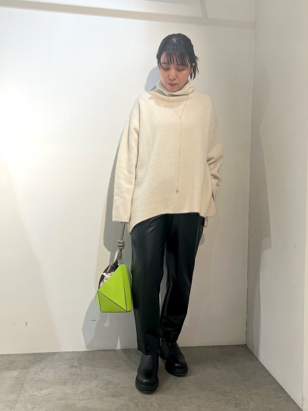 ブラック系のその他パンツ、ホワイト系のニット/セーター、グリーン系のチェスターコートを着用したレディースの冬コーディネートの3枚目の写真