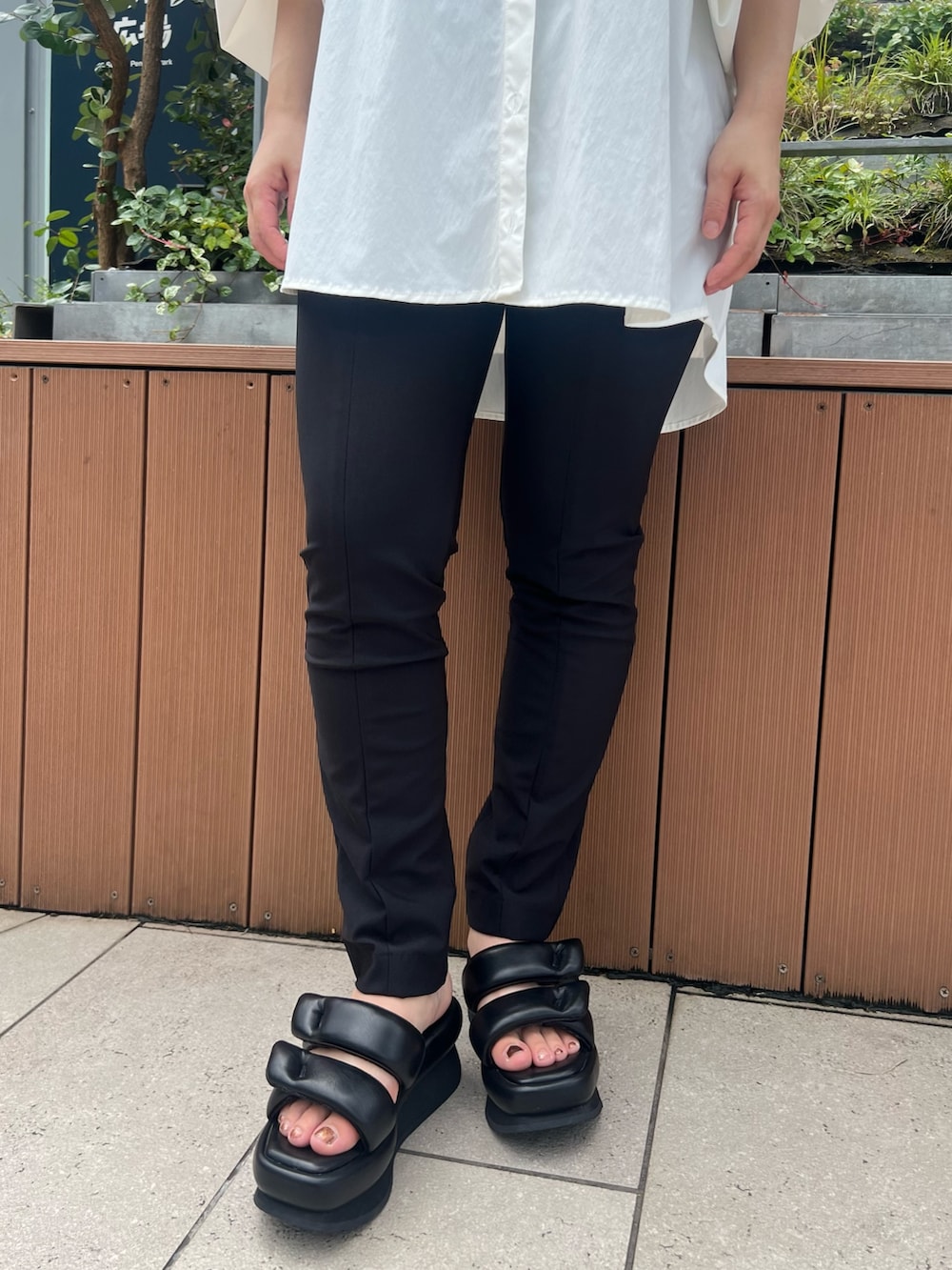 ブラック系のその他パンツ、ブラック系のサンダル、ホワイト系のブルゾンを着用したレディースの夏コーディネートの6枚目の写真