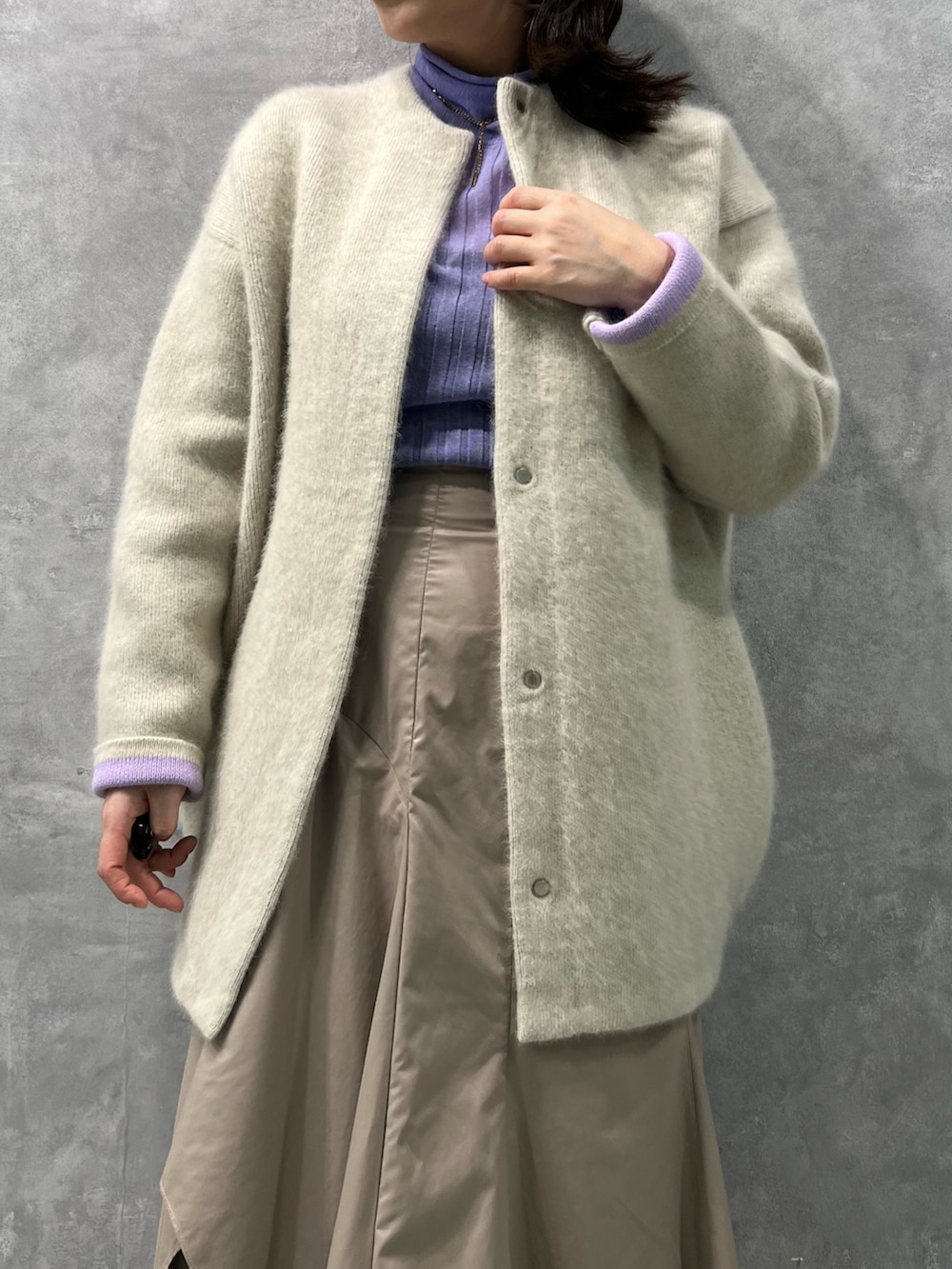 ホワイト系のノーカラージャケット、パープル系のニット/セーター、ベージュ系のスカートを着用したレディースの夏コーディネートの5枚目の写真