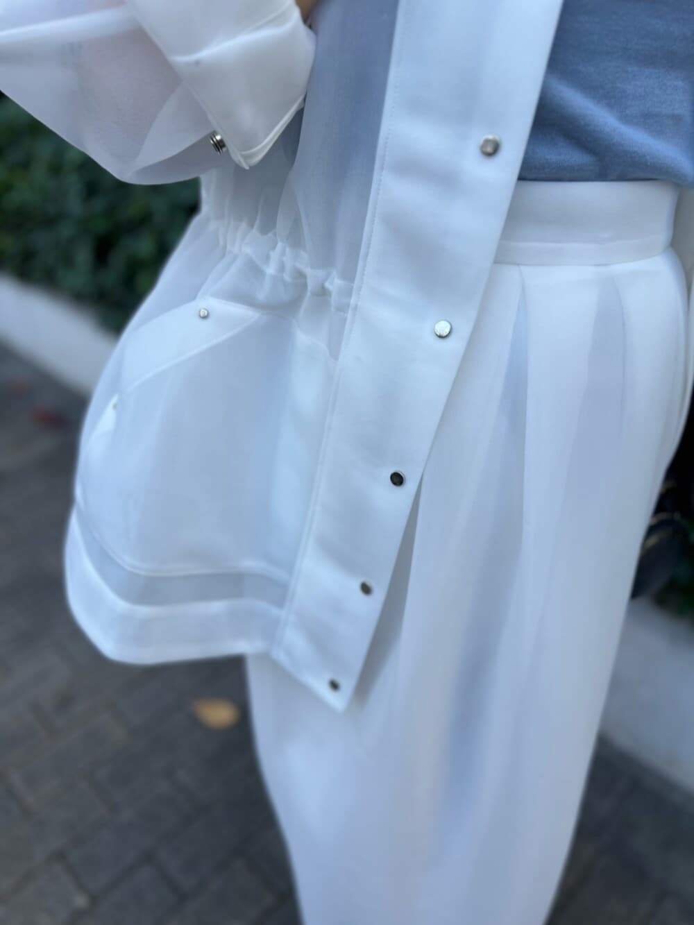 ホワイト系のその他アウター、ブルー系のニット/セーター、ホワイト系のスカートを着用したレディースの秋コーディネートの7枚目の写真